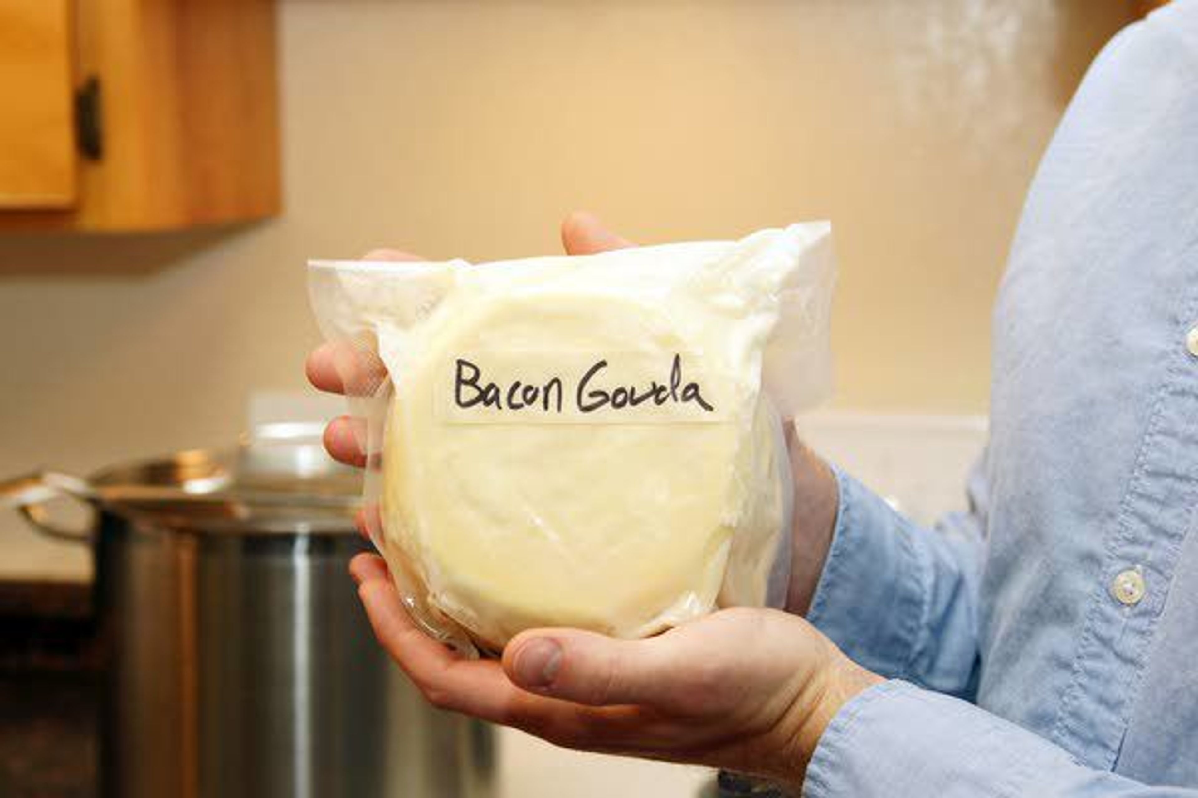 Jobe Ritchie holds a package of bacon gouda cheese he made.