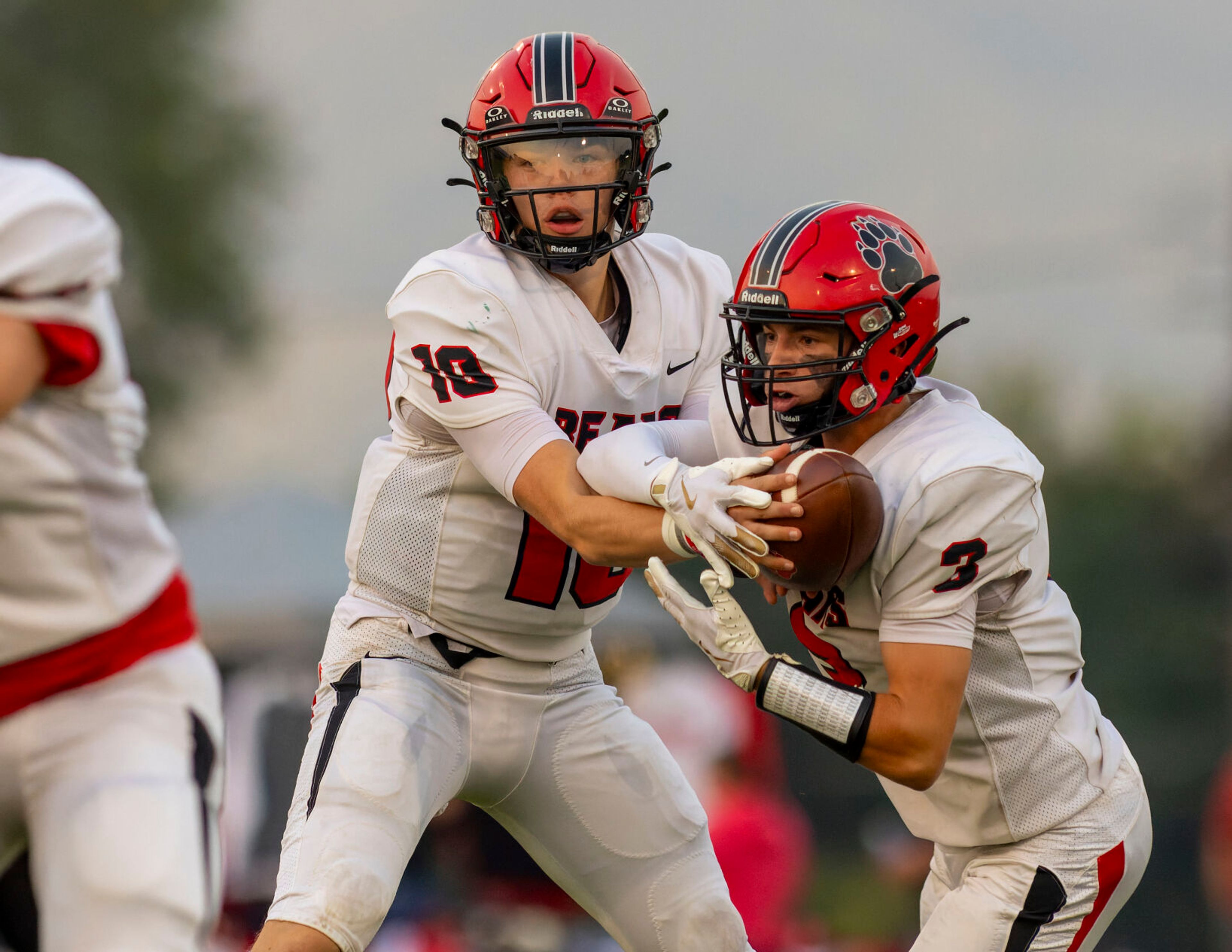 Moscow quarterback Noah Velasco, left, hands the ball of to running back Tyson Izzo during a game against the Clarkston Bantams on Friday in Clarkston.