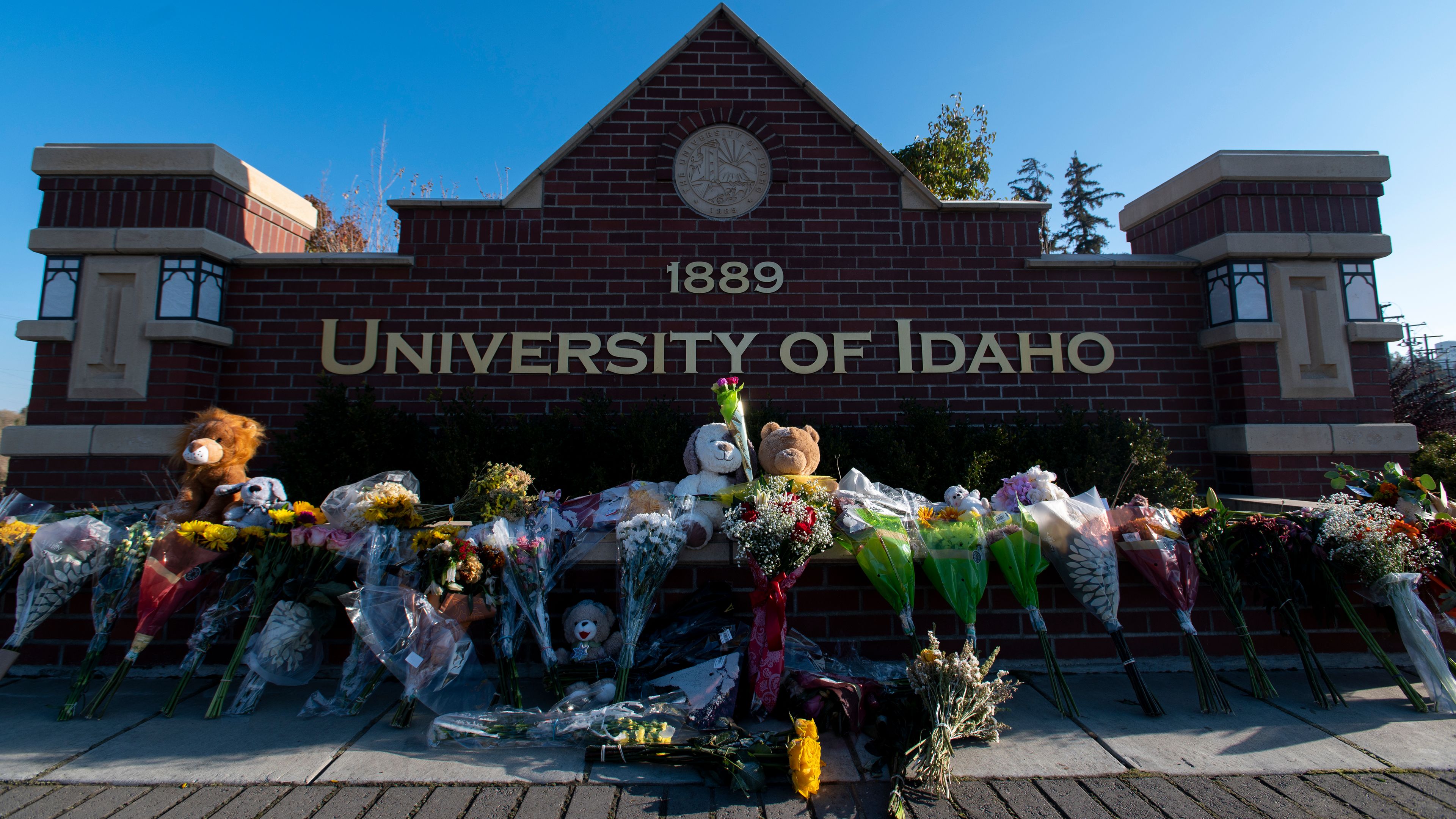 Flowers and stuffed animals rest next to a University of Idaho sign along Pullman Road in Moscow Nov. 16.