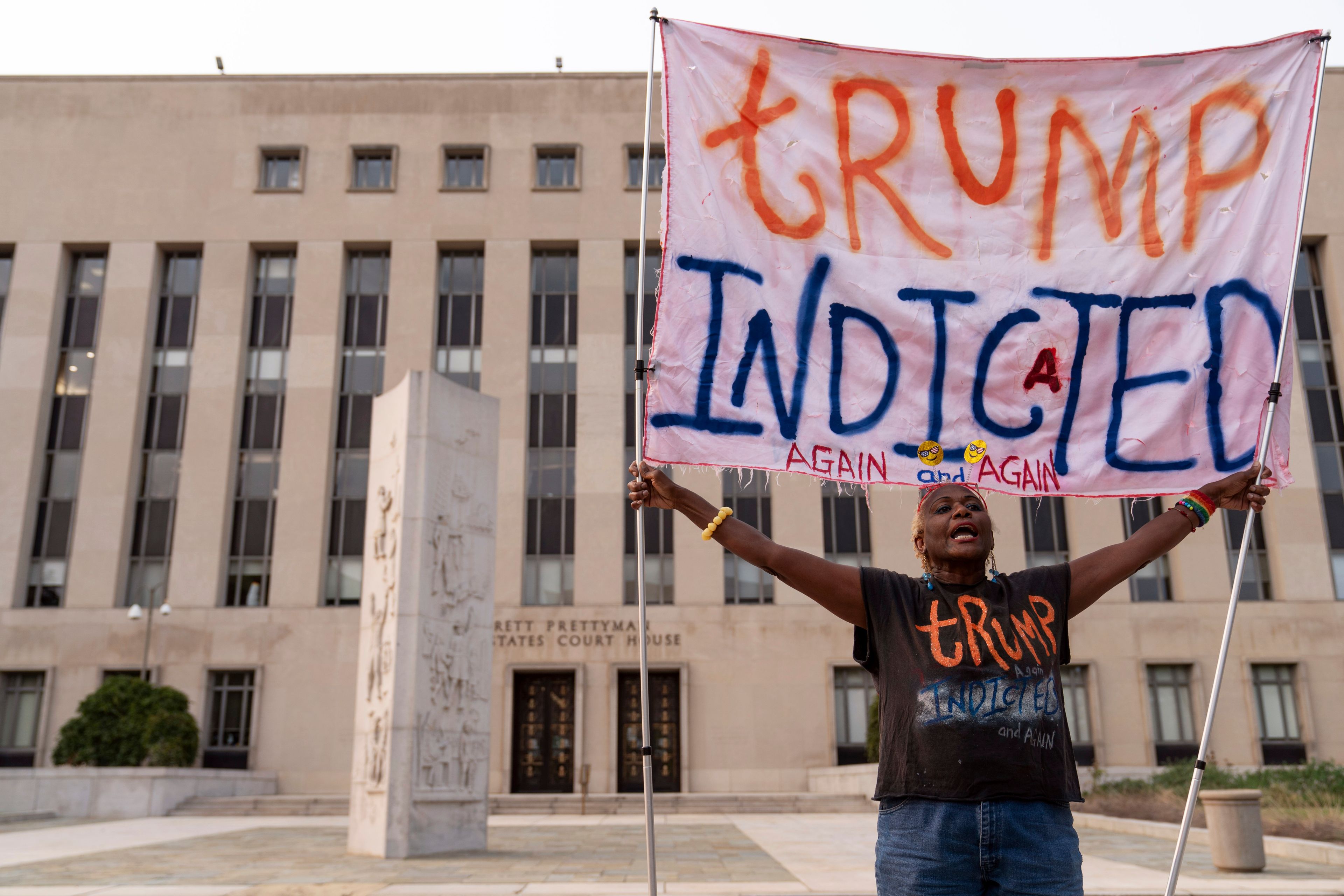 Nadine Seiler protest as she holds a banner outside federal court Tuesday, Aug. 1, 2023 in Washington. Former President Donald Trump has been charged by the Justice Department for his efforts to overturn the results of the 2020 presidential election. (AP Photo/Jose Luis Magana)