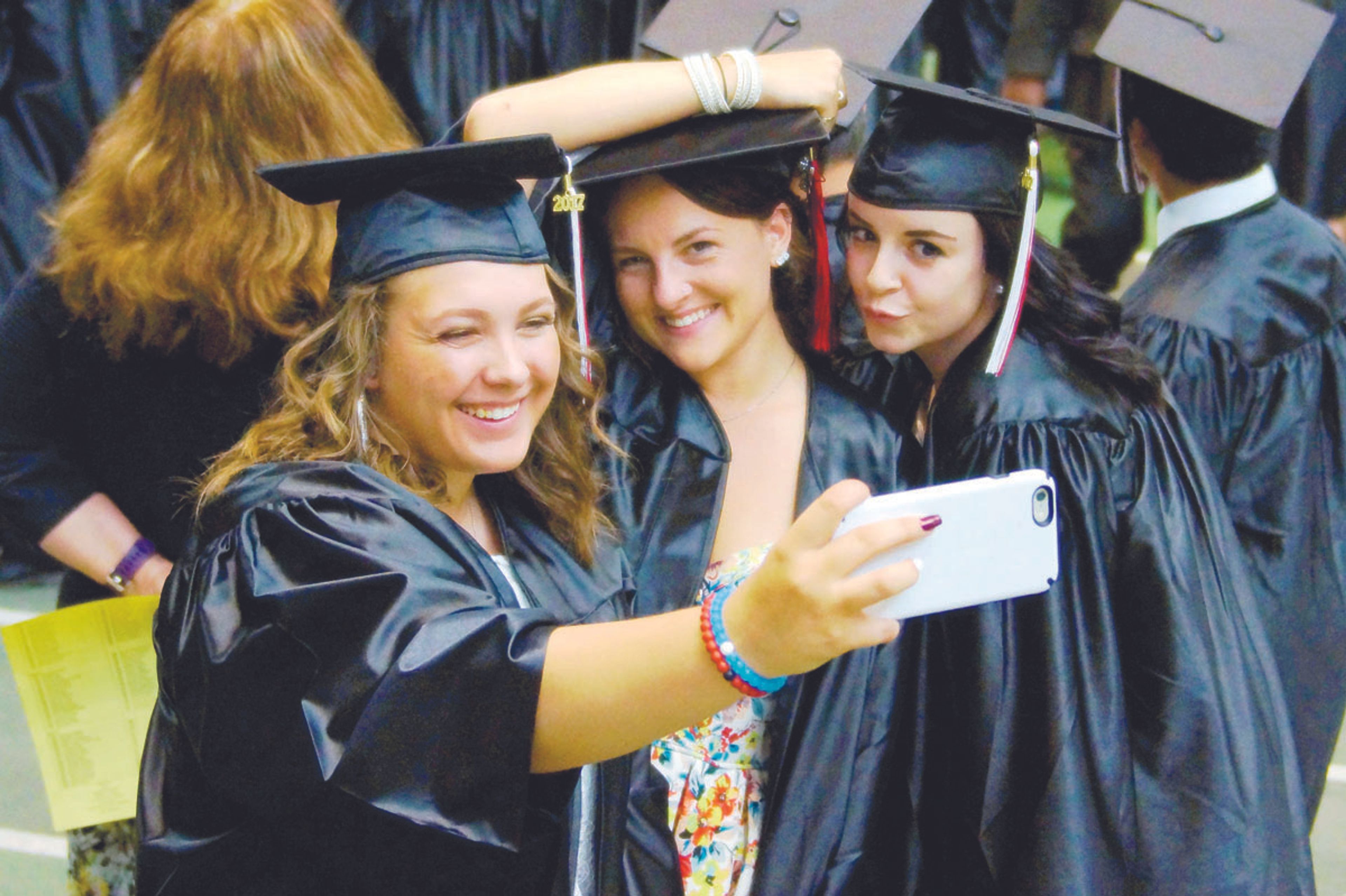 Emma French, left, Reese Bentley and Holly Kozlowski pose for a selfie before Moscow High School's graduation ceremony Friday evening.