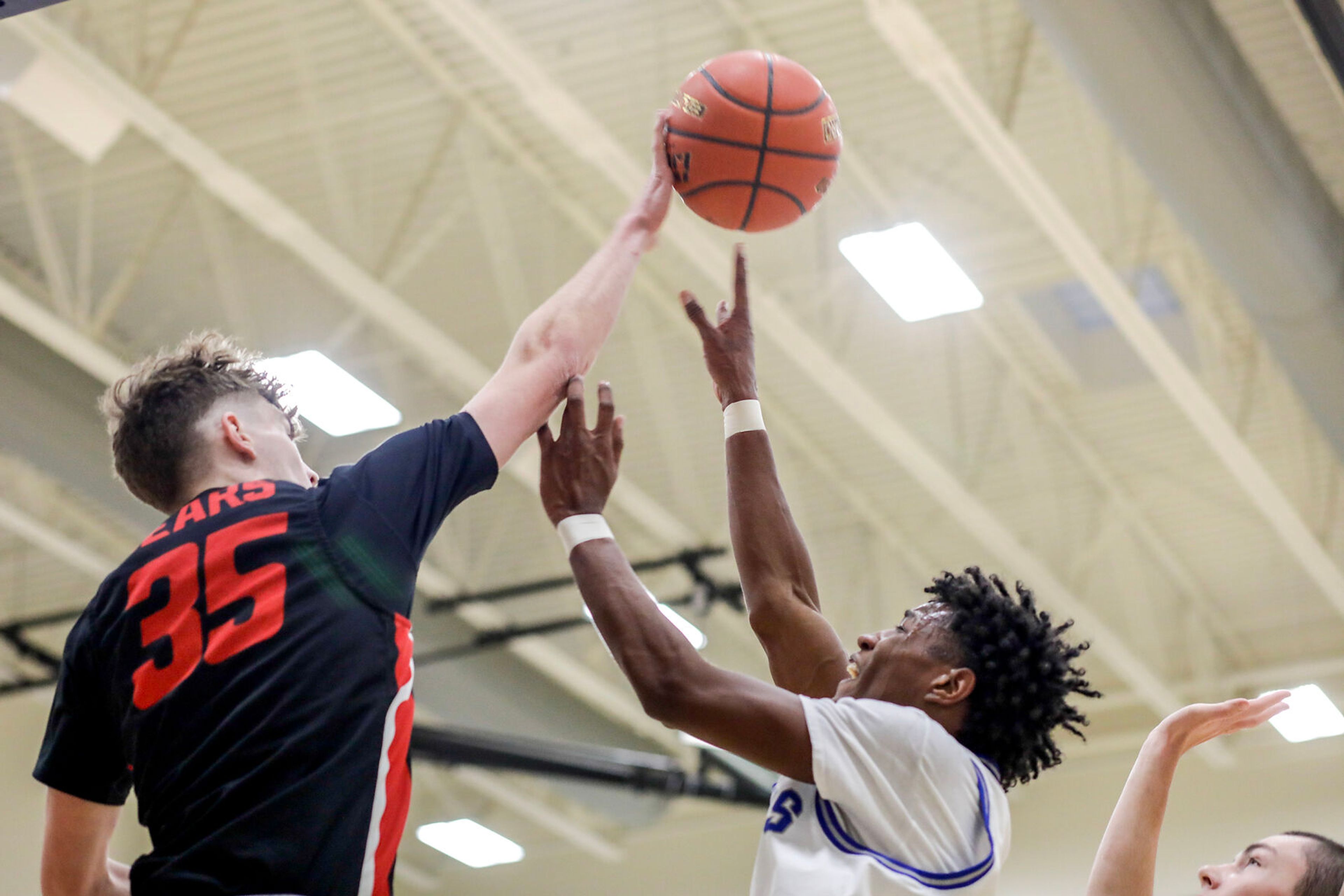 Moscow guard Ian Hillman, left, blocks the shot of Pullman shooting guard Champ Powaukee during Saturday's nonleague boys basketball game.