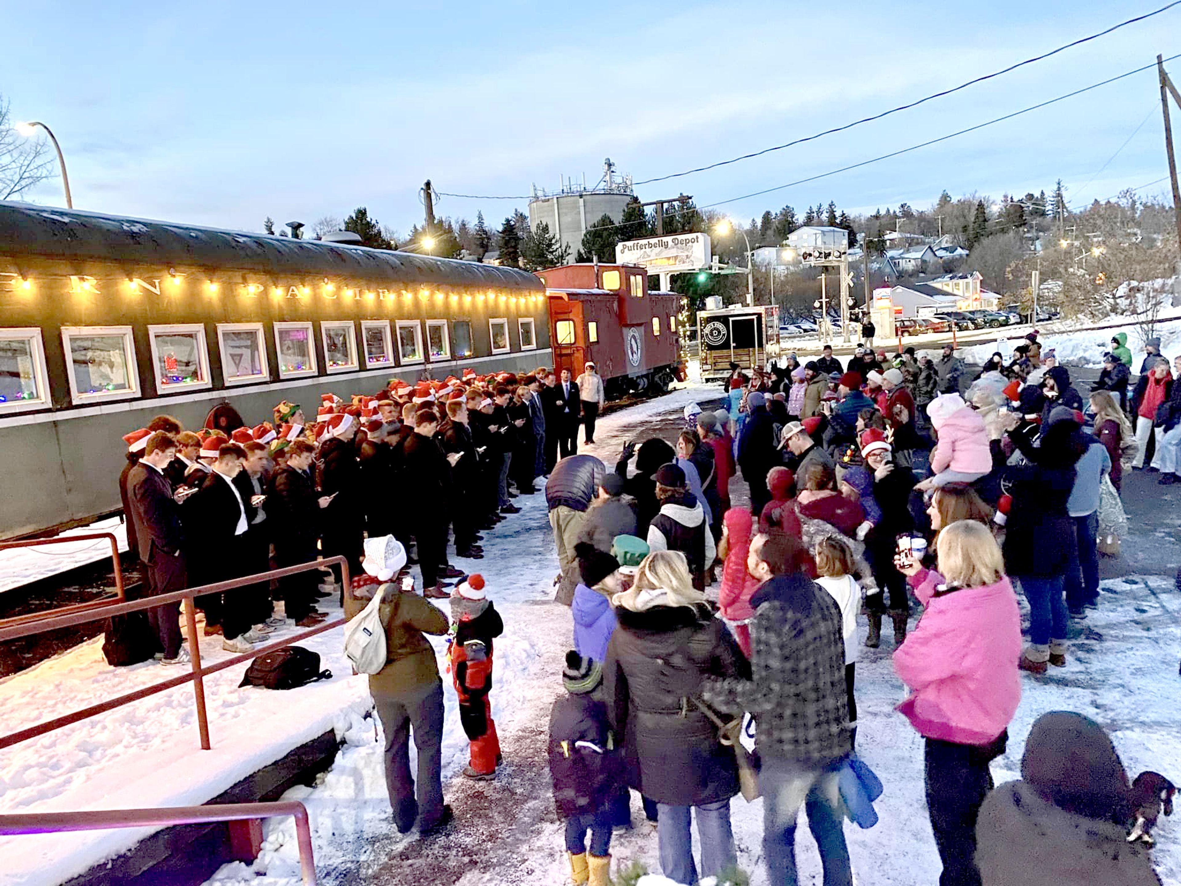 A healthy crowd, right, gathered at the Pullman Depot Heritage Center on Saturday and was treated to the vocal stylings of the Sigma Phi Epsilon fraternity from Washington State University while it awaited the arrival of Santa Claus. The chorus and Santa visit were part of the Pullman Holiday Festival organized by by the Pullman Chamber of Commerce, Pullman Civic Trust and the Downtown Pullman Association. Photo by Jamie Whitman.