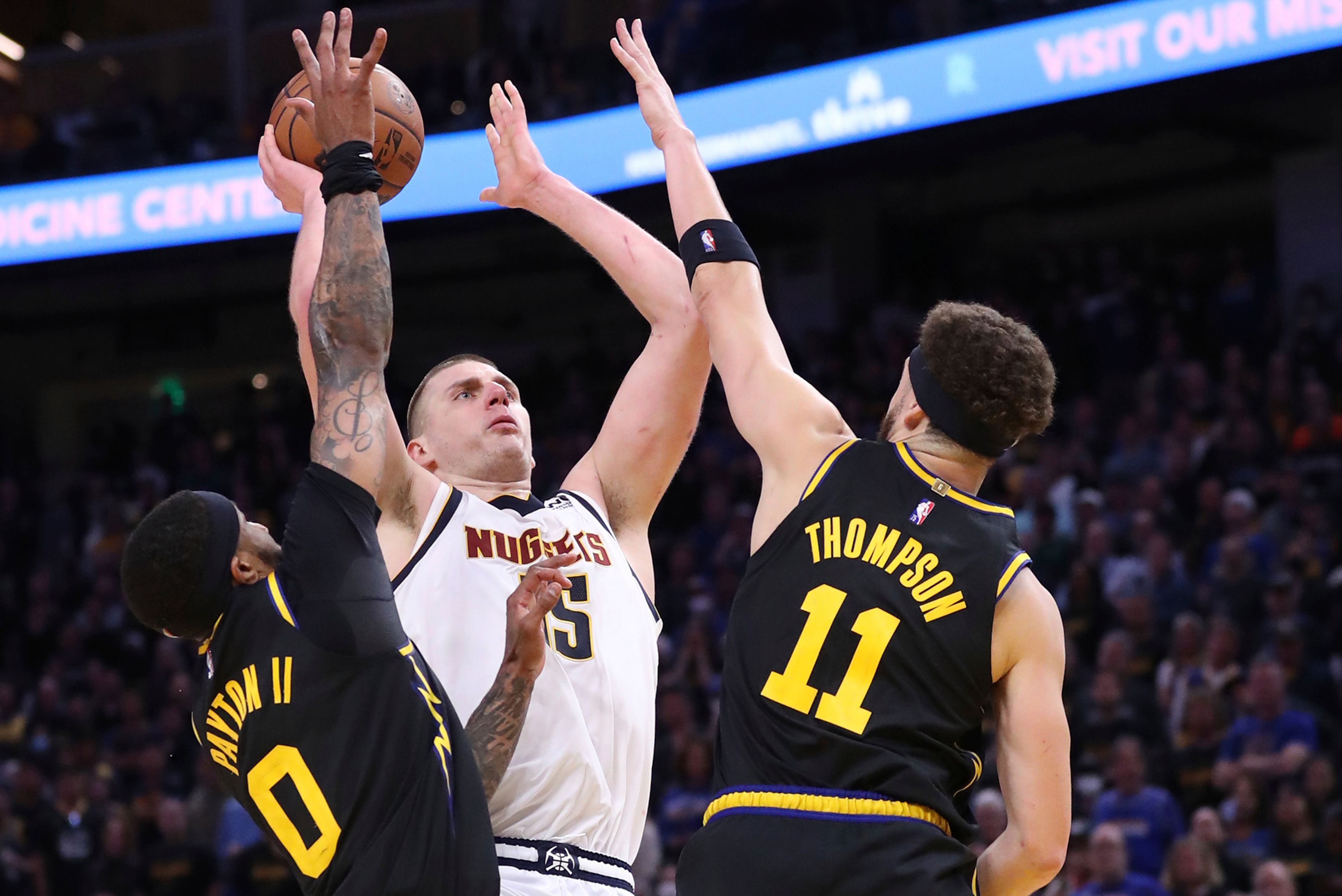 Golden State Warriors' Gary Payton II and Klay Thompson guard Denver Nuggets' Nikola Jokic in 4th quarter during Warriors' 102-98 win in Game 5 of NBA Western Conference First Round playoff game at Chase Center in San Francisco, Calif, on Wednesday, April 27, 2022.(Scott Strazzante/San Francisco Chronicle via AP)