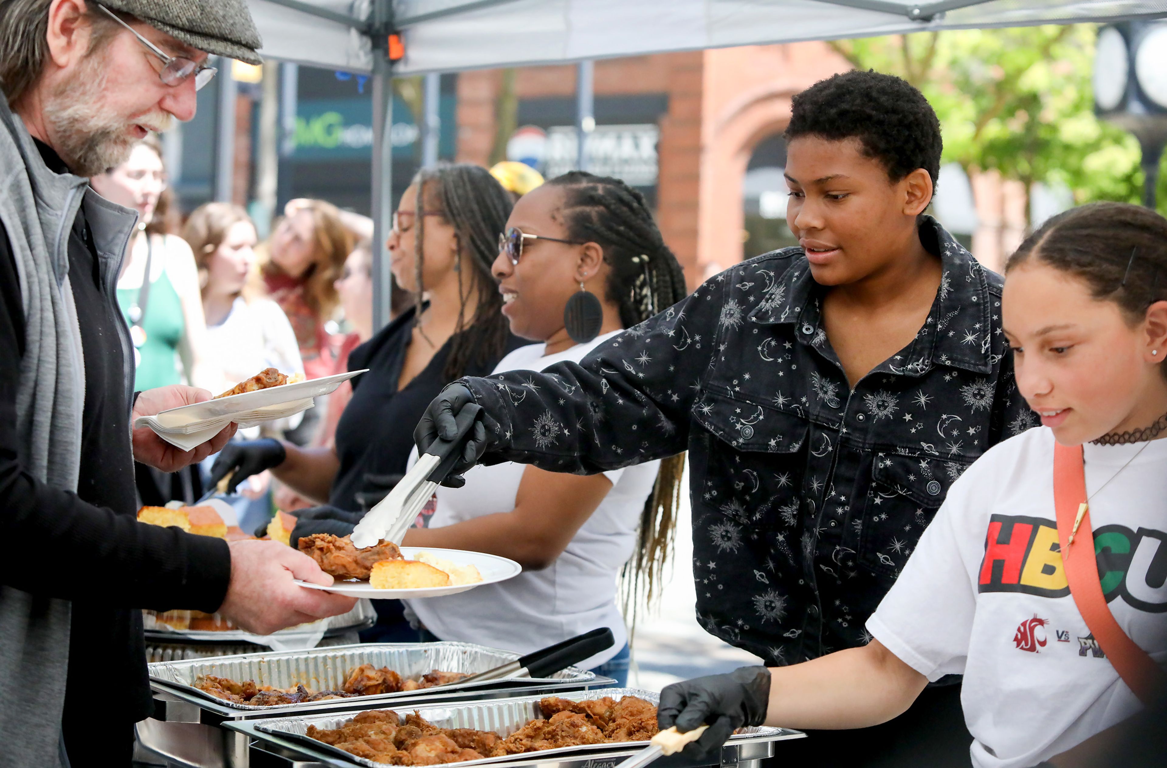 Miehla Samuels, center, of Moscow, helps serve free soul food at the Juneteenth celebration at Friendship Square on Wednesday in Moscow.