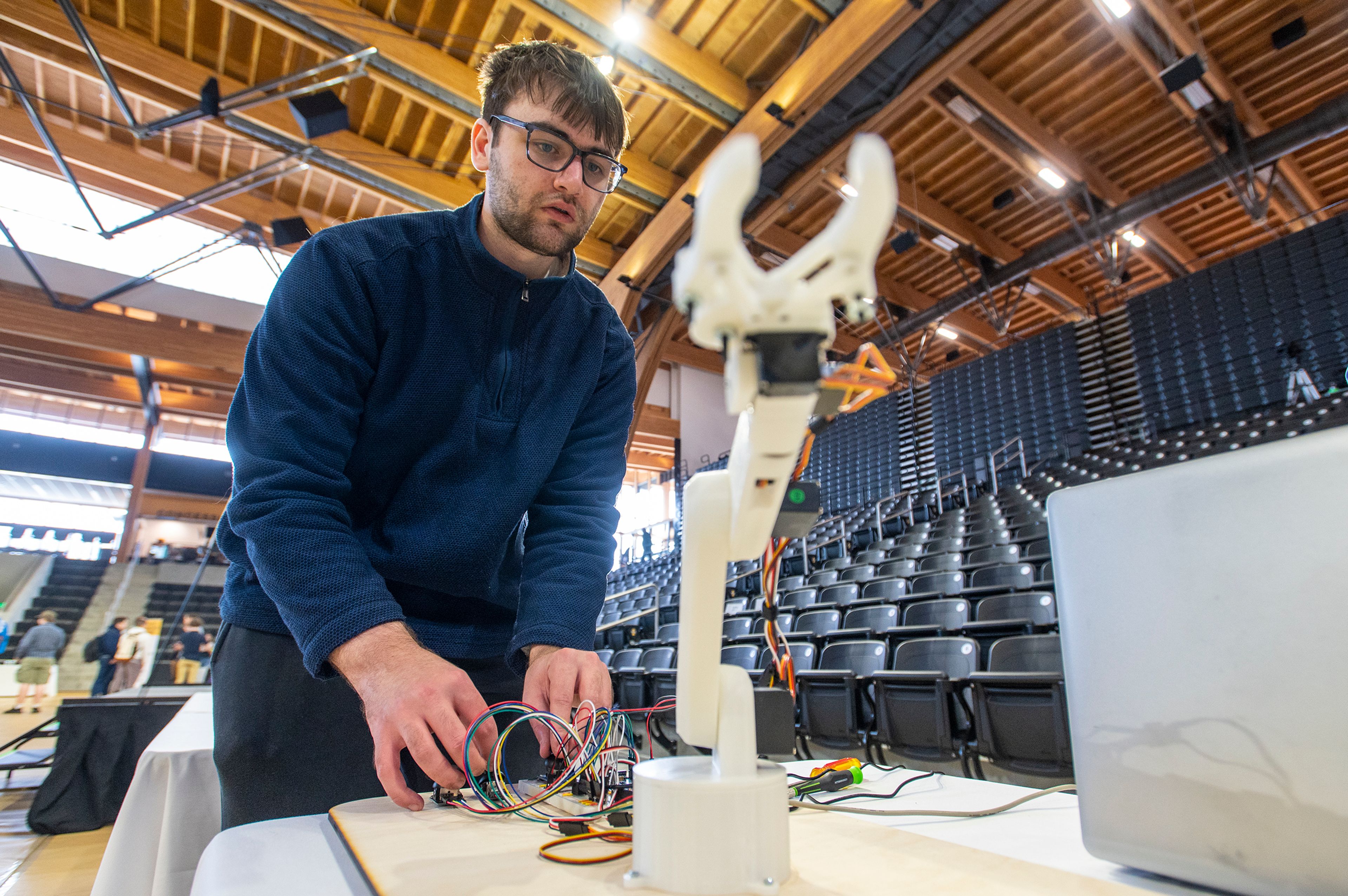 David Reetz, a junior in the University of Idaho Vandal Robotics Club, controls a robotic arm during the University of Idaho College of Engineering’s annual Engineering Design Expo in the Idaho Central Credit Union Arena on Friday morning in Moscow. Reetz said he is enjoying his first year with the Vandal Robotics Club and encouraged others to join and help “build a knowledge base so future students know what to do and what not to do.”