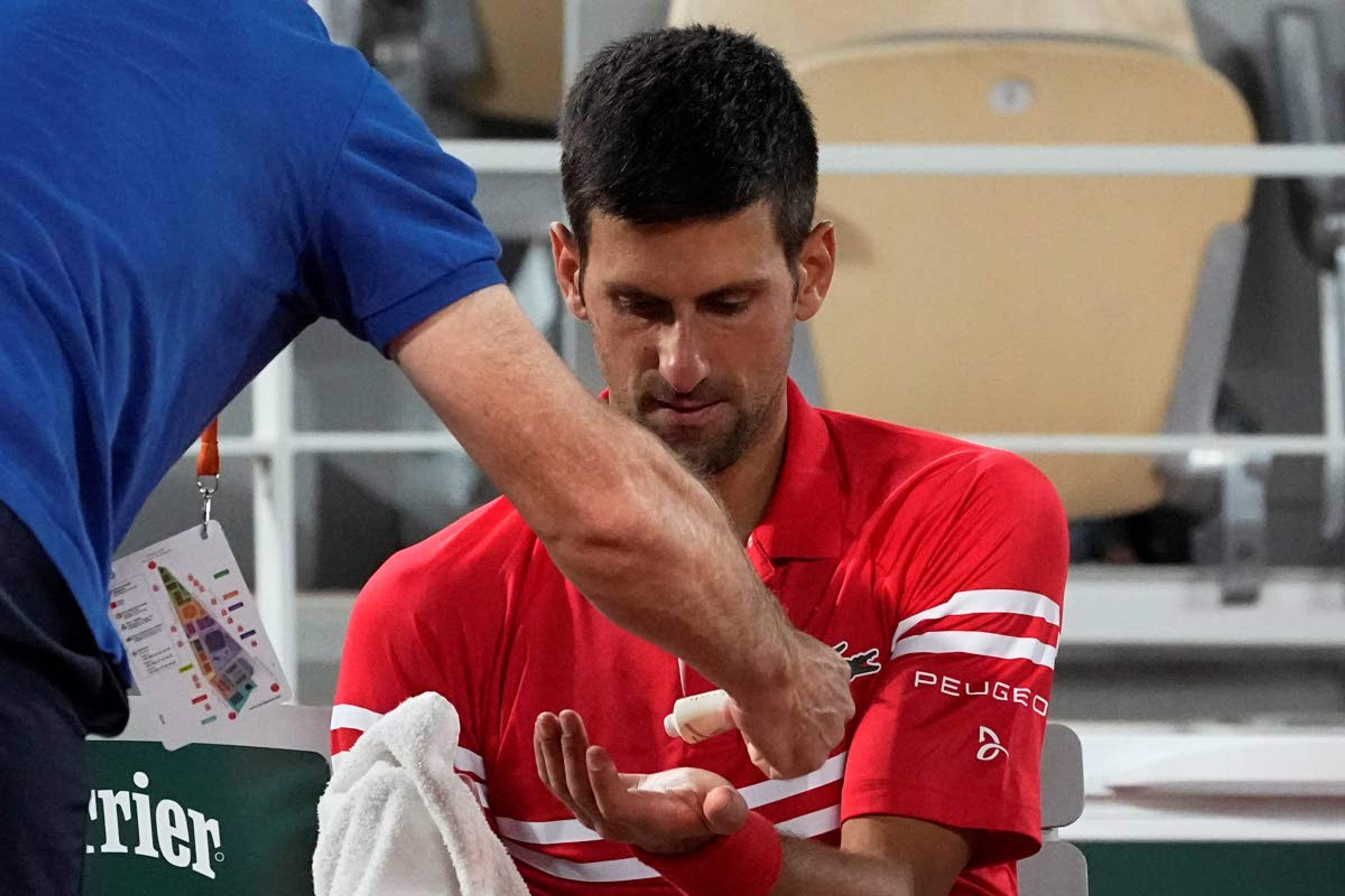 Serbia's Novak Djokovic gets some cream in his hand during a break as he plays Italy's Matteo Berrettini in a quarterfinal match of the French Open tennis tournament at the Roland Garros stadium Wednesday, June 9, 2021 in Paris. (AP Photo/Michel Euler)