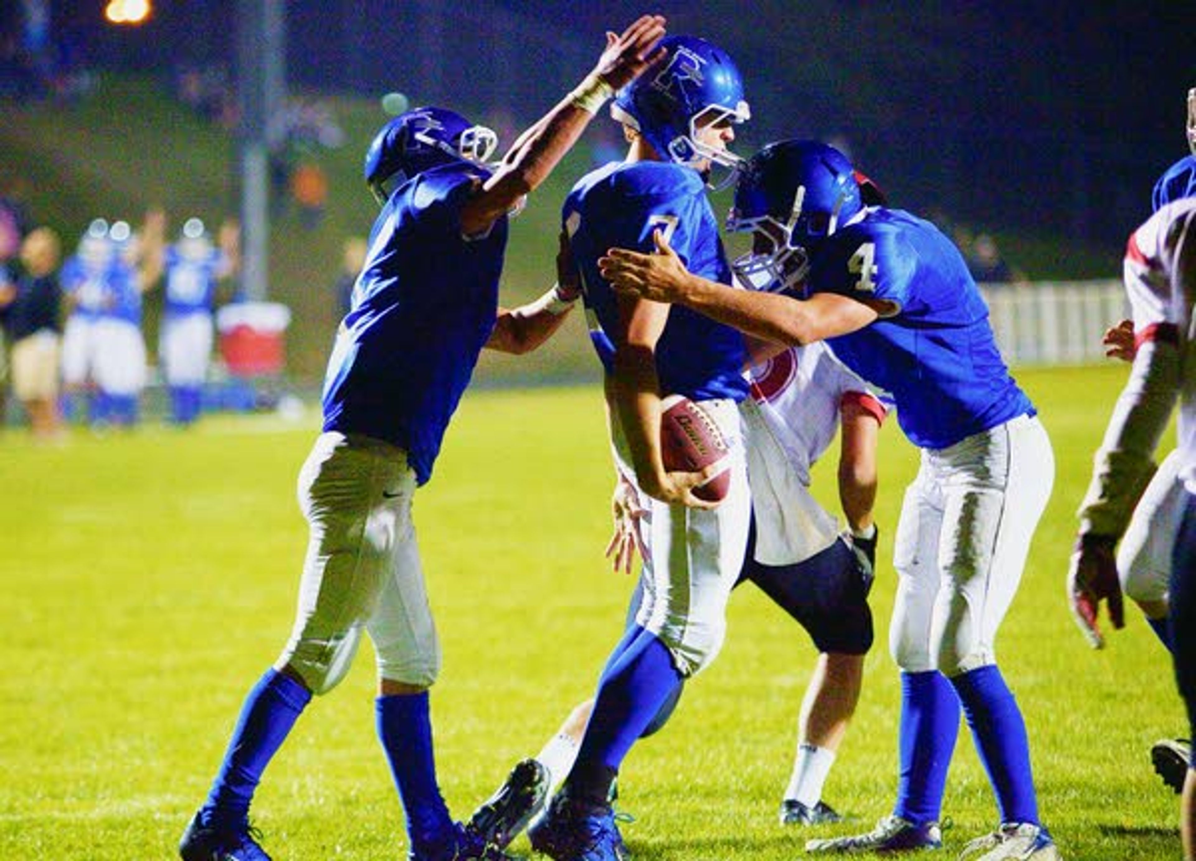 Pullman teammates congratulate quarterback Just Cillay, center, after he scored a touchdown during the second quarter against Moscow on Sept. 15 at Hobbs Field in Pullman.