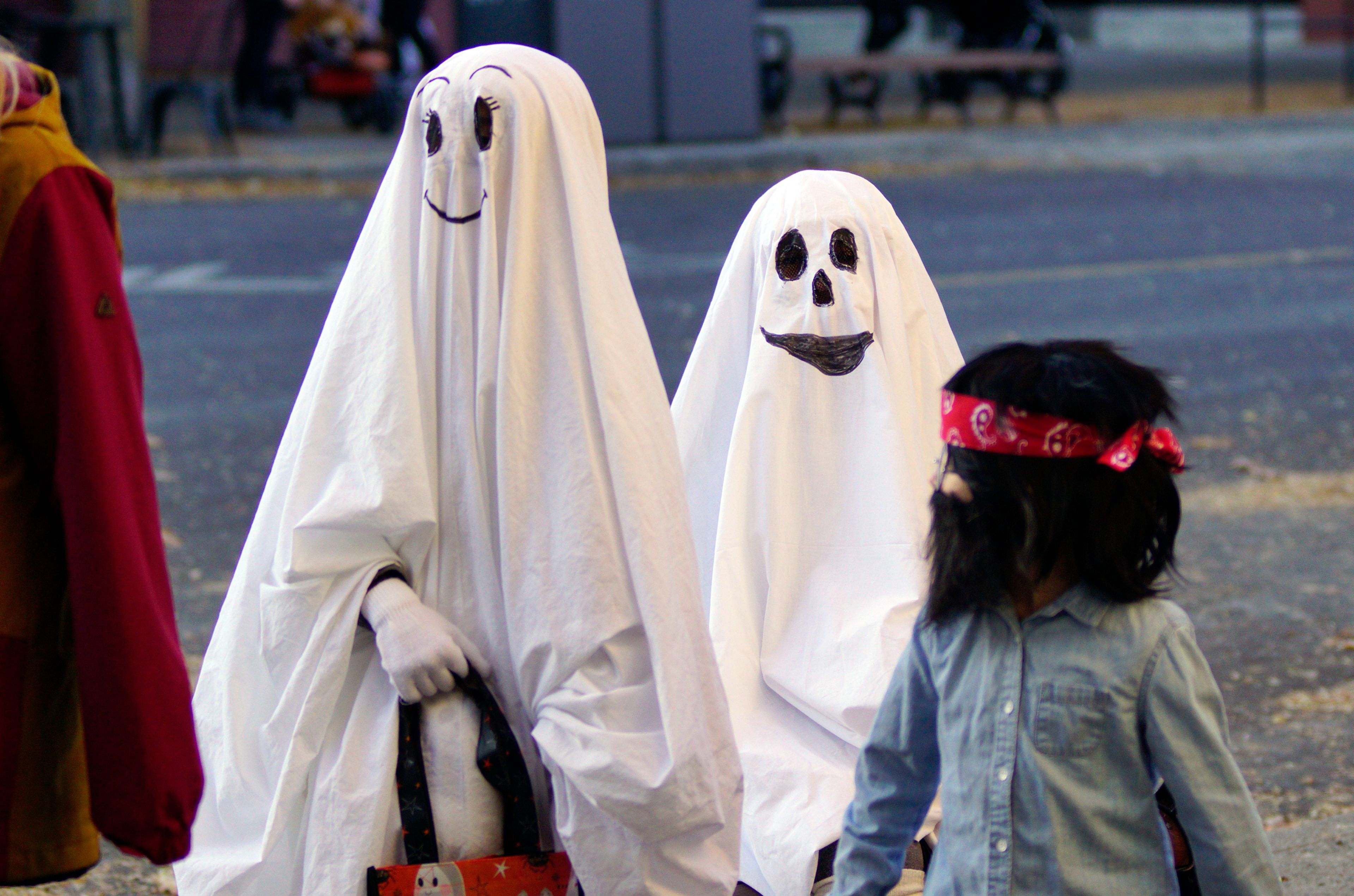 A pair of ghosts watch passers by Thursday evening in downtown Moscow during the annual Halloween trick or treating event.                                ,