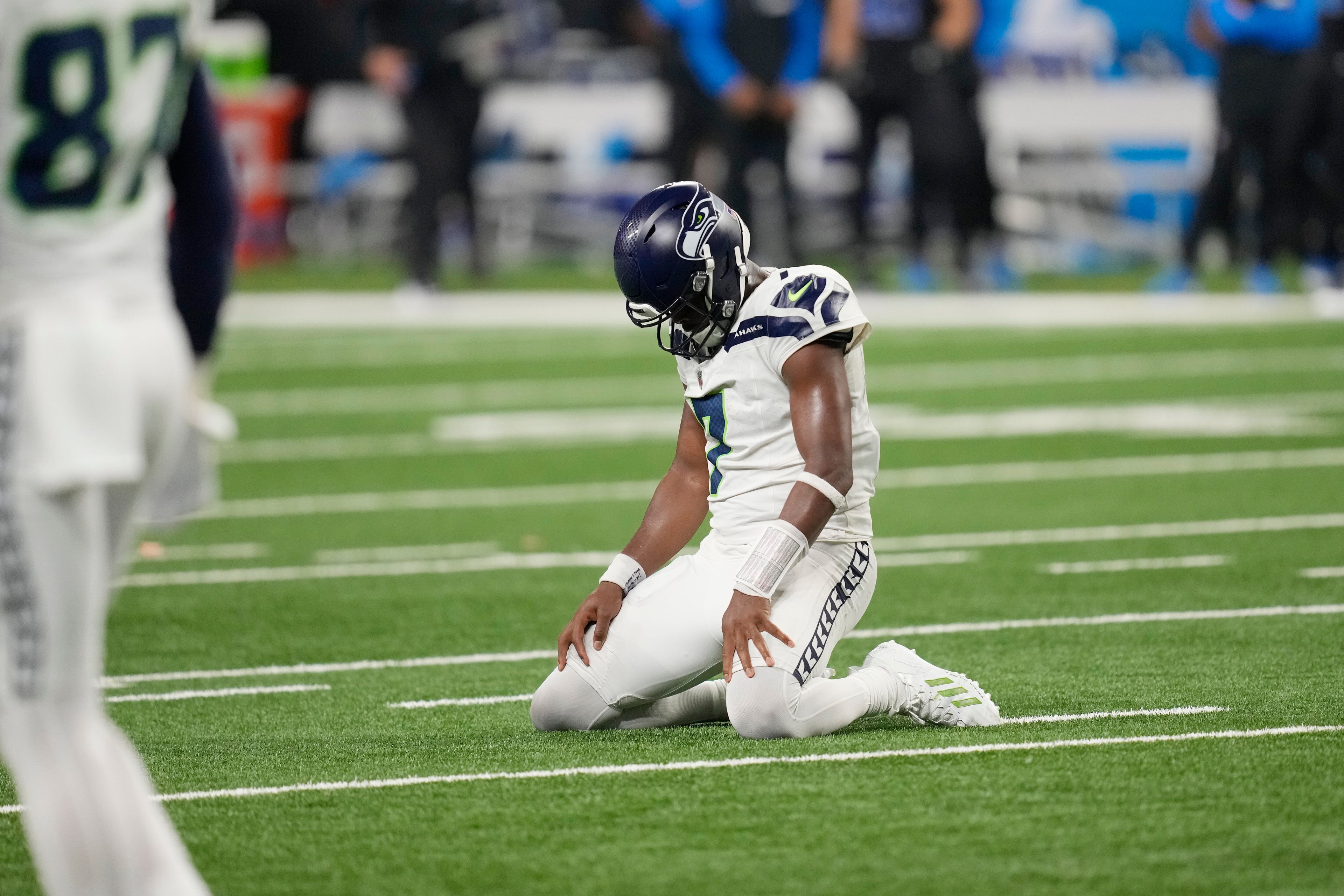 Seattle Seahawks quarterback Geno Smith kneels on the field after a play during the second half of an NFL football game against the Detroit Lions, Monday, Sept. 30, 2024, in Detroit. (AP Photo/Paul Sancya)