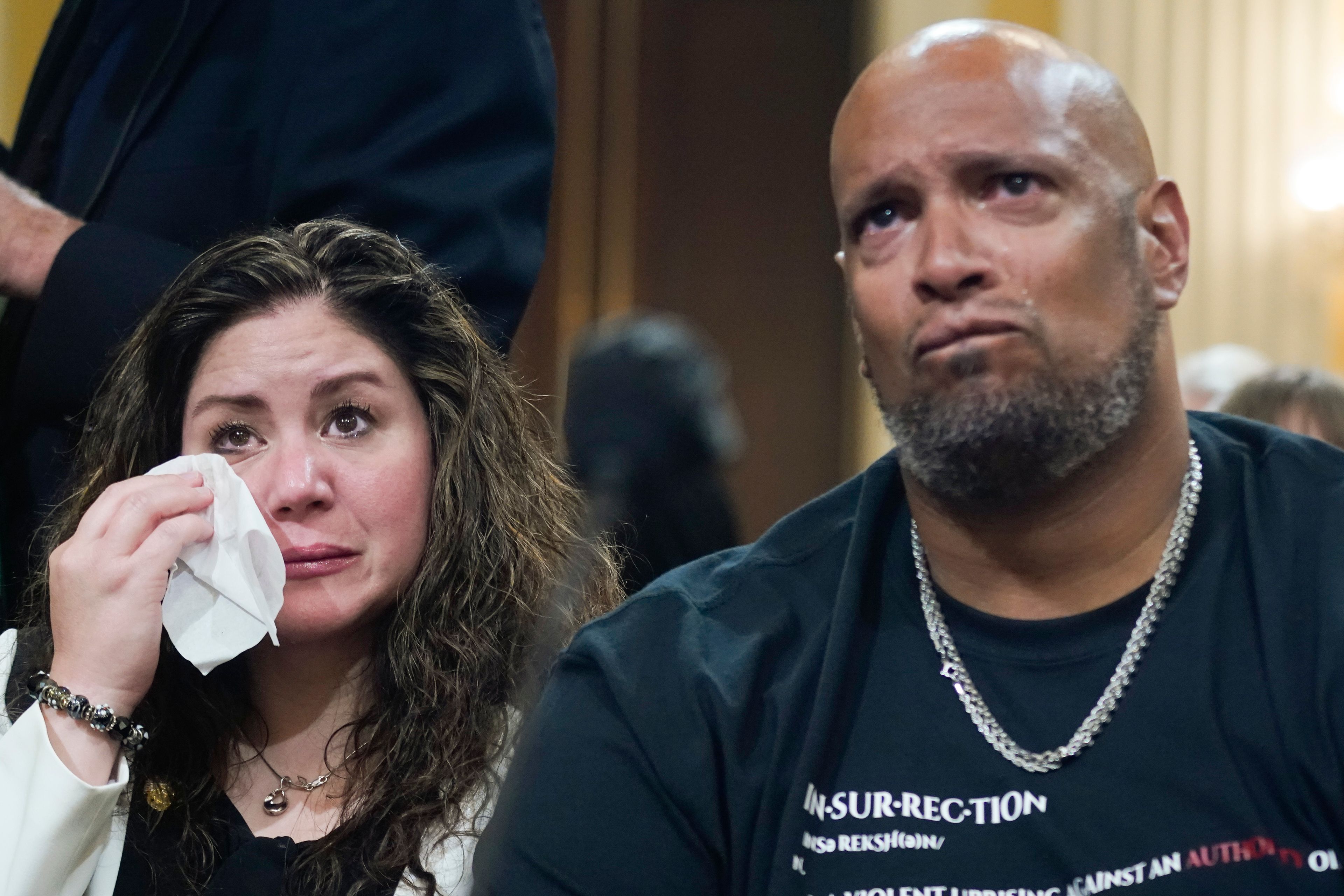 U.S. Capitol Police Sgt. Harry Dunn, right, and Sandra Garza, the long-time partner of Capitol Hill Police Officer Brian Sicknick who died shortly after the Jan. 6 attack, left, react as a video of the Jan. 6 attack on the U.S. Capitol is played during a public hearing of the House select committee investigating the attack is held on Capitol Hill, Thursday, June 9, 2022, in Washington. (AP Photo/Andrew Harnik)