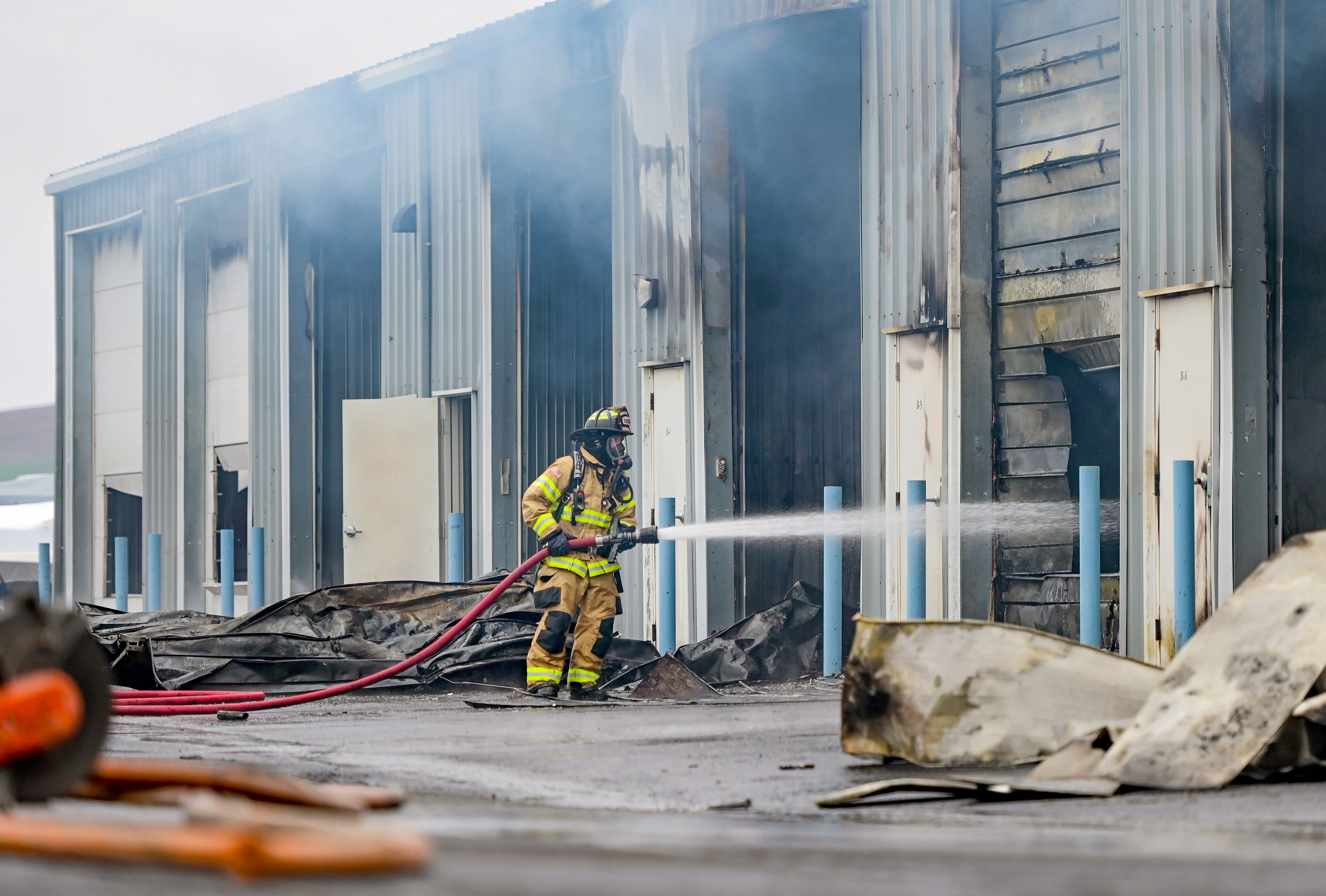 Smoke escapes from storage units at Express Storage as fire crews continue spraying the units in the aftermath of a large fire along Moscow-Pullman Highway on Thursday.