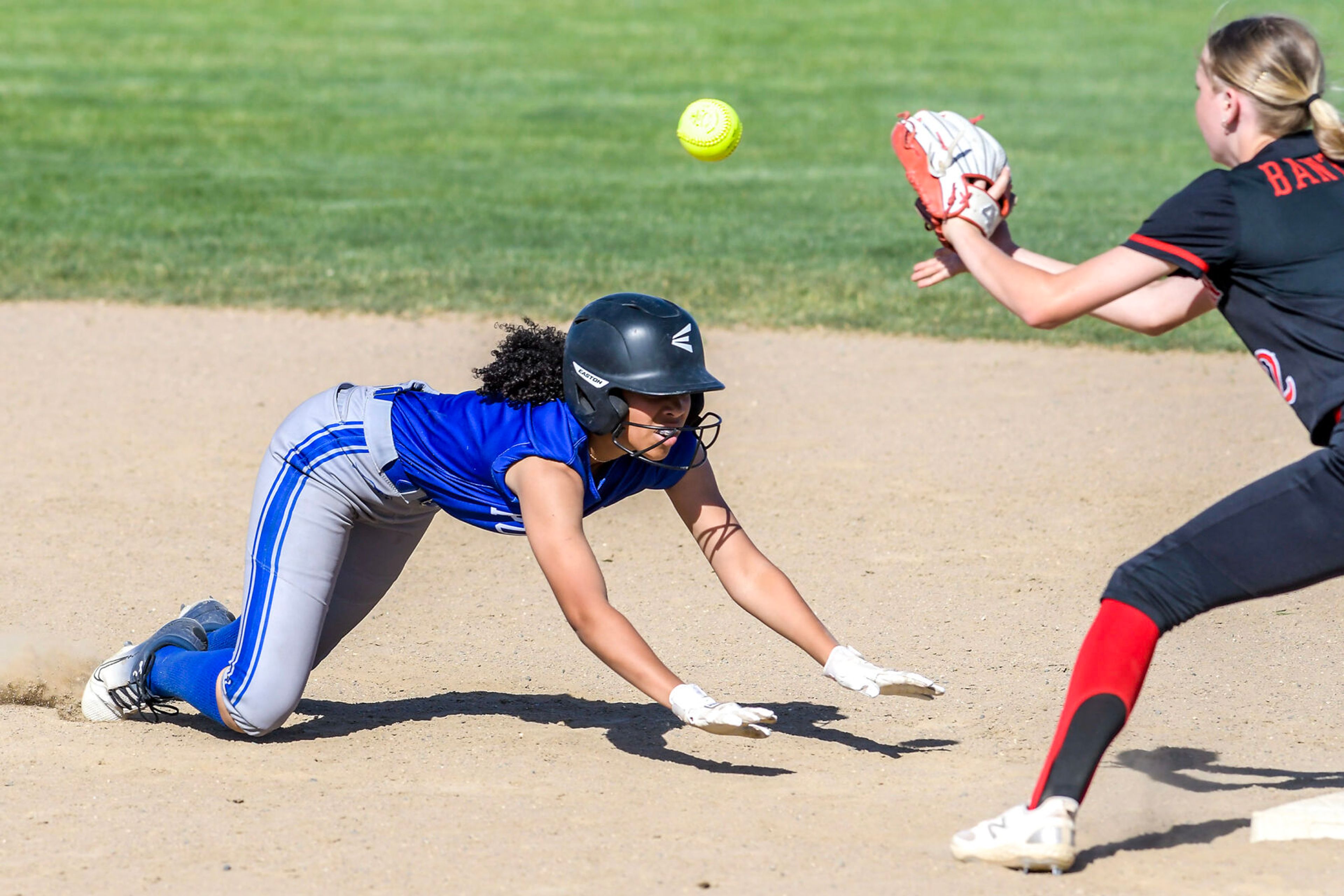 Pullman’s Charisse Kapofu dives back to second base as Clarkston second baseman Aneysa Judy prepares to make the catch and tag her out in an inning of a district tournament semifinal round game Thursday in Clarkston.