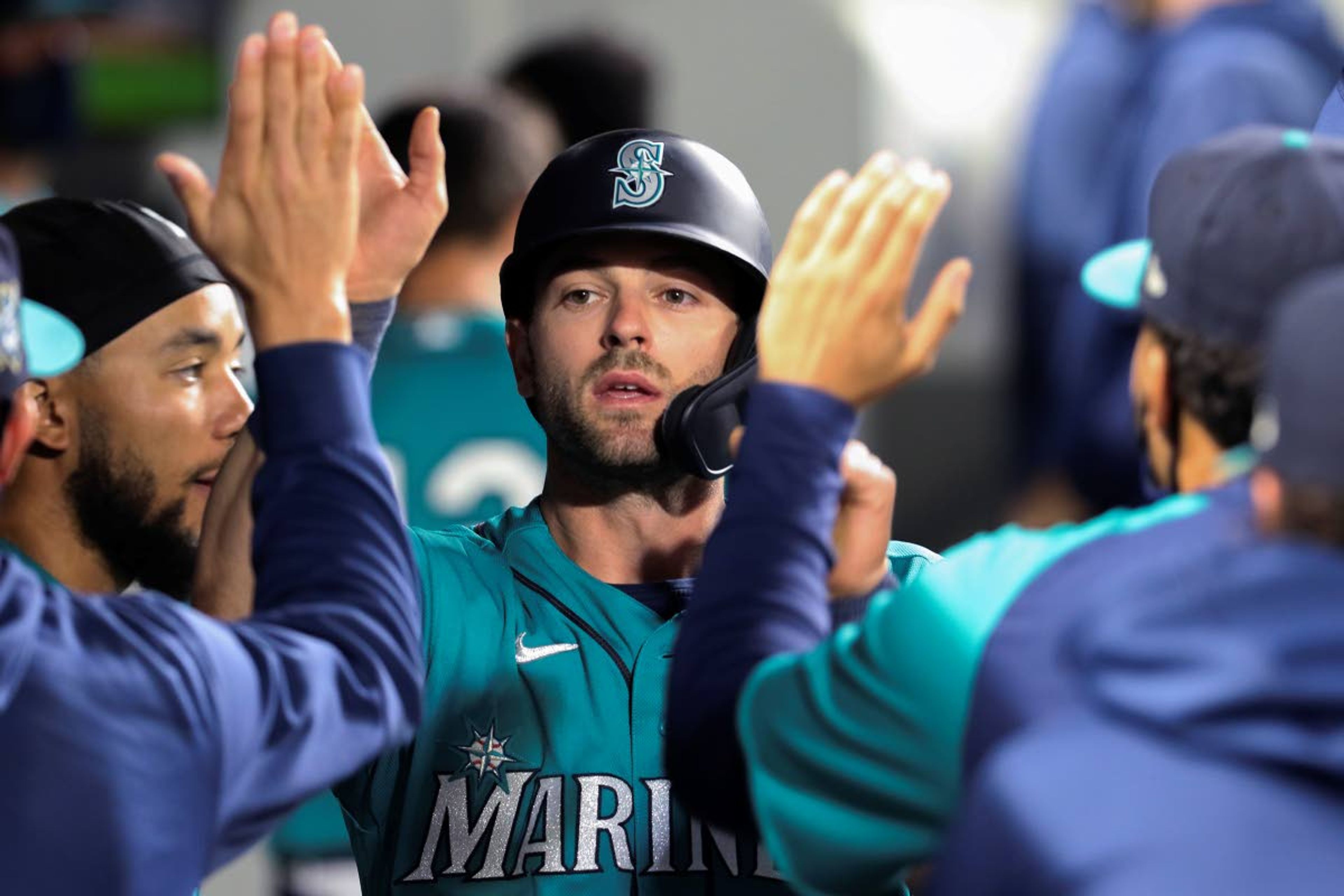 Seattle Mariners' Mitch Haniger celebrates in the dugout after scoring on a Kyle Seager double during the sixth inning of the team's baseball game against the Houston Astros on Friday, April 16, 2021, in Seattle. (AP Photo/Jason Redmond)