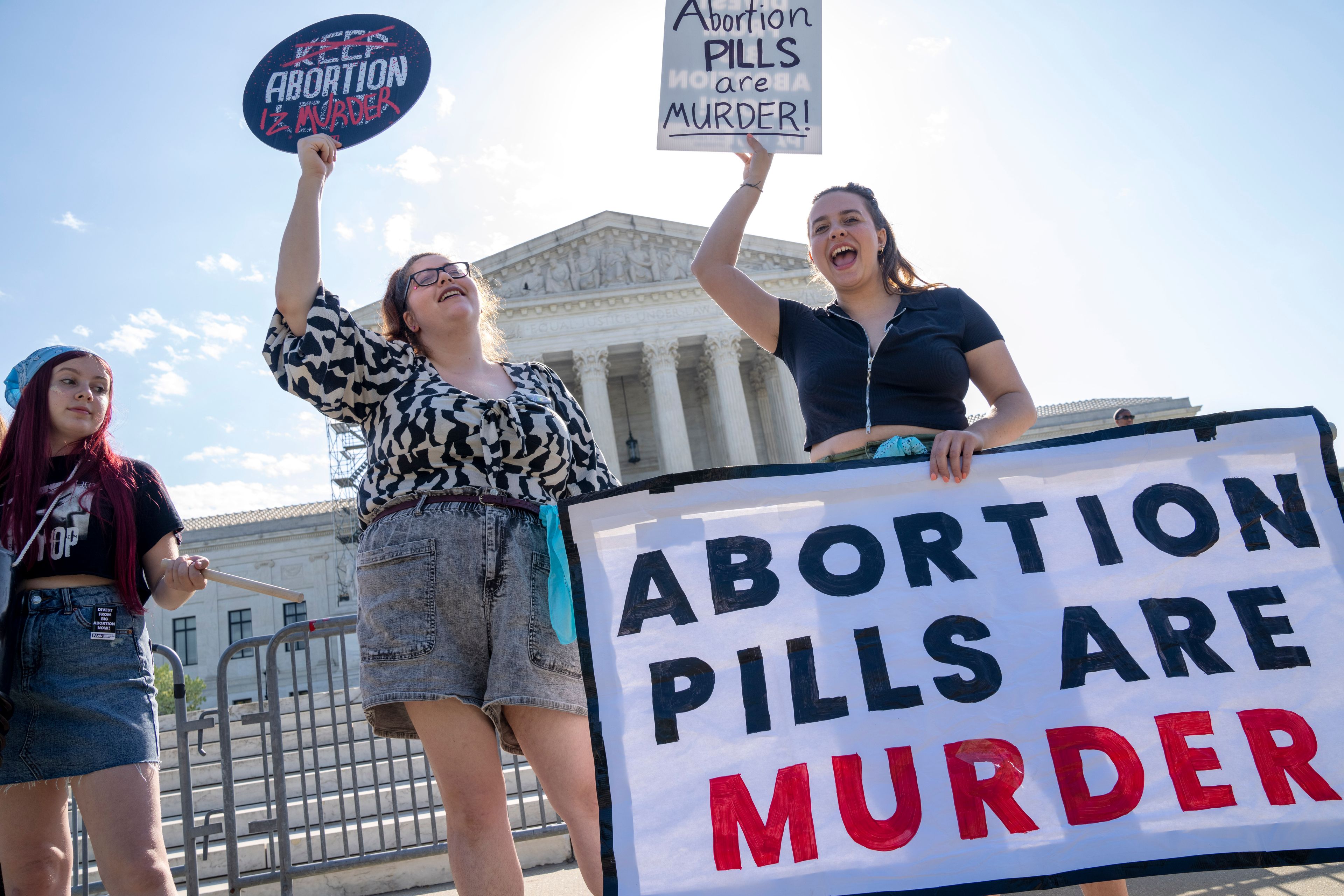 Staff with the group, Progressive Anti-Abortion Uprising, Kristin Turner, of San Francisco, left, Lauren Handy, of Washington, and Caroline Smith, of Washington, right, demonstrate against abortion pills outside of the Supreme Court, Friday, April 21, 2023, ahead of an abortion pill decision by the court in Washington. (AP Photo/Jacquelyn Martin)