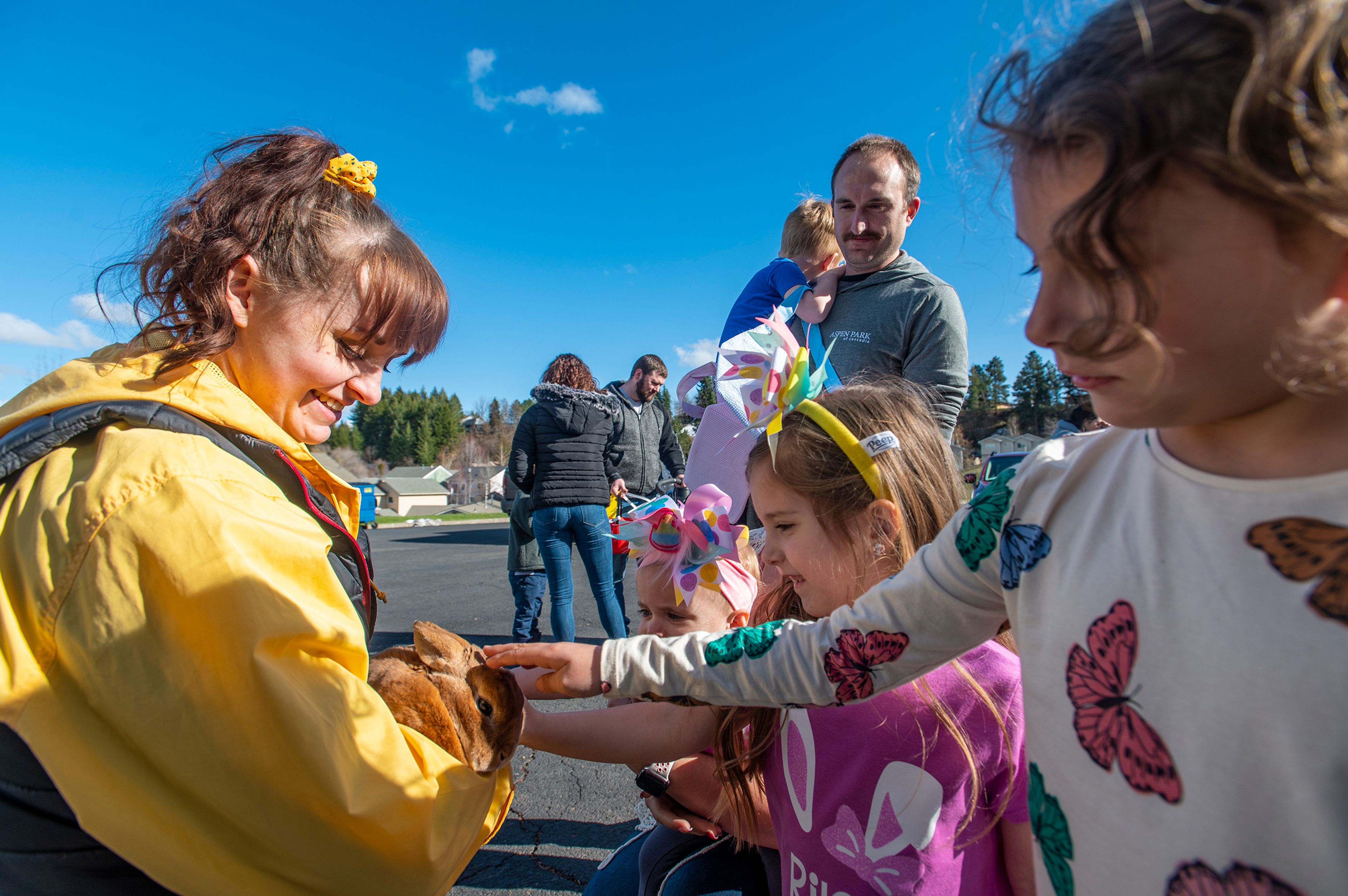 Employee Sarah Baird holds her rabbit, Caramel, for Isabelle Defilippo, 1, from left, Riley Defilippo, 5, and Alli Whitright, 6, to gently pet during the annual Easter egg hunt Friday at Aspen Park of Cascadia in Moscow.