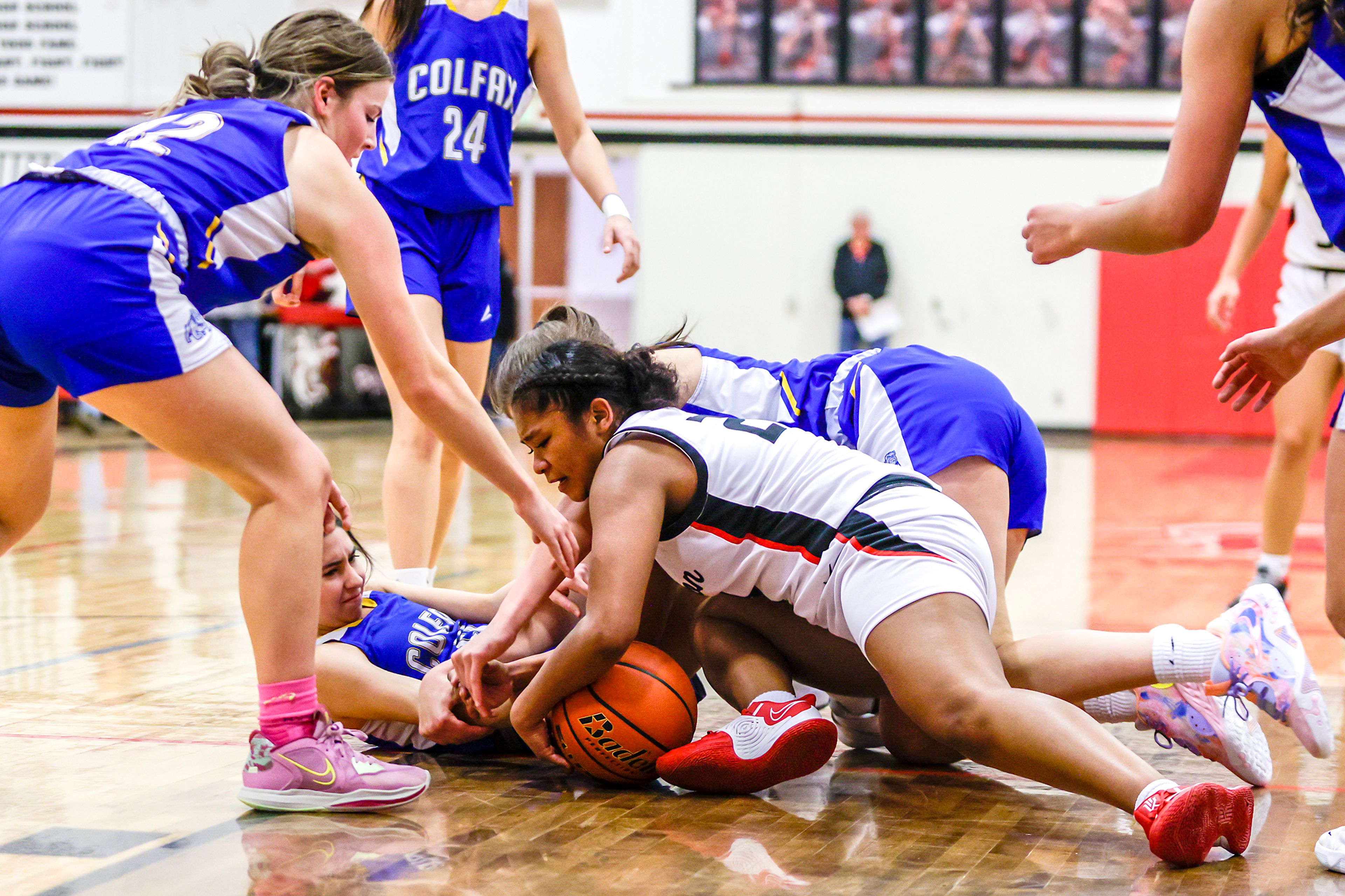 Clarkston wing Samara Powaukee (right) wrestles for a loose ball with Colfax guards Jaisha Gibb in a quarter of a nonleague game Thursday at Clarkston.