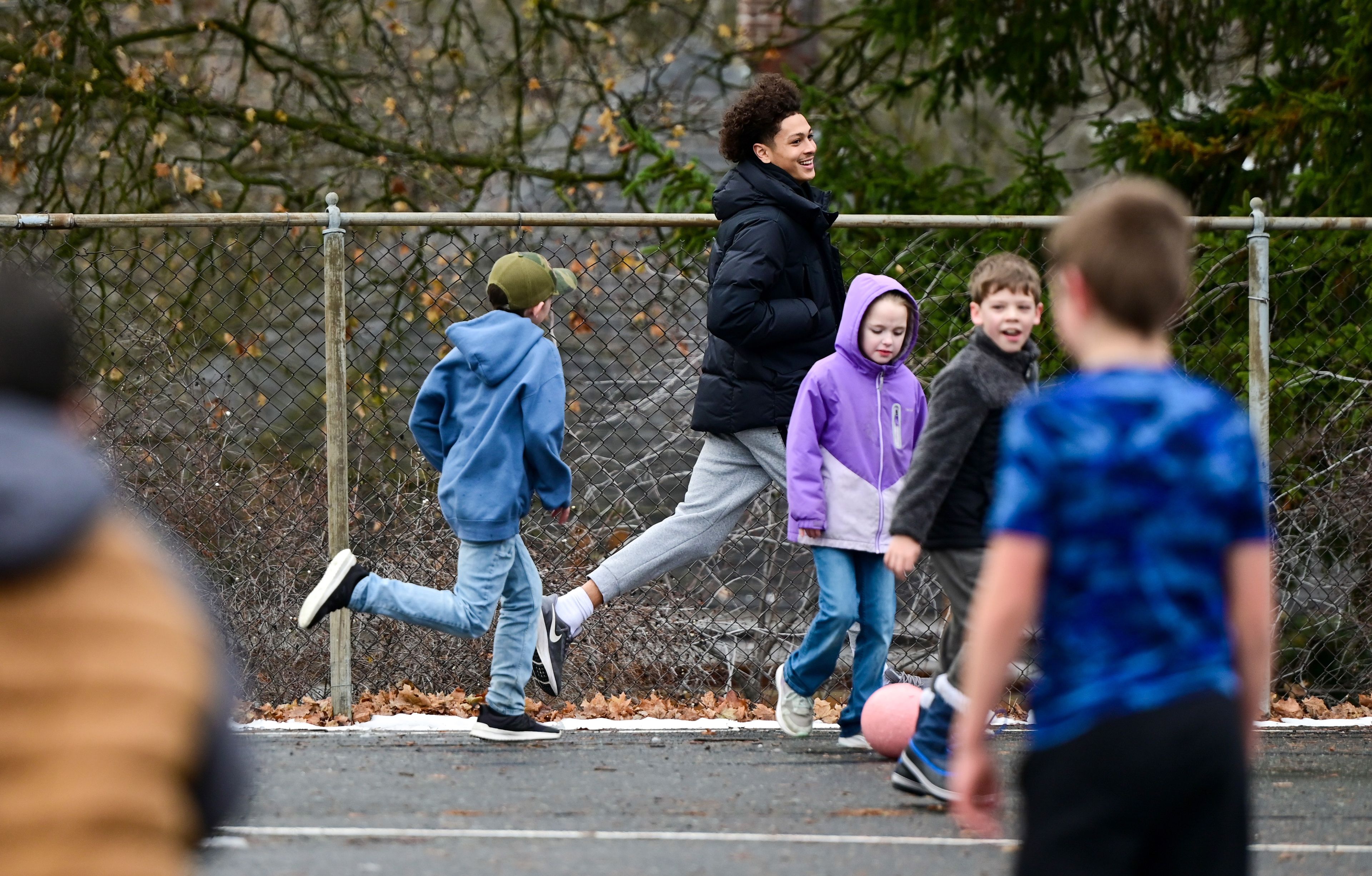 Idaho Vandal Trevon Blassingame, center, is chased across the courtyard by fifth grader Henri, left, during recess at John Russell Elementary School in Moscow on Monday. The Vandals visit with students a few times each month during lunch and recess as mentors.