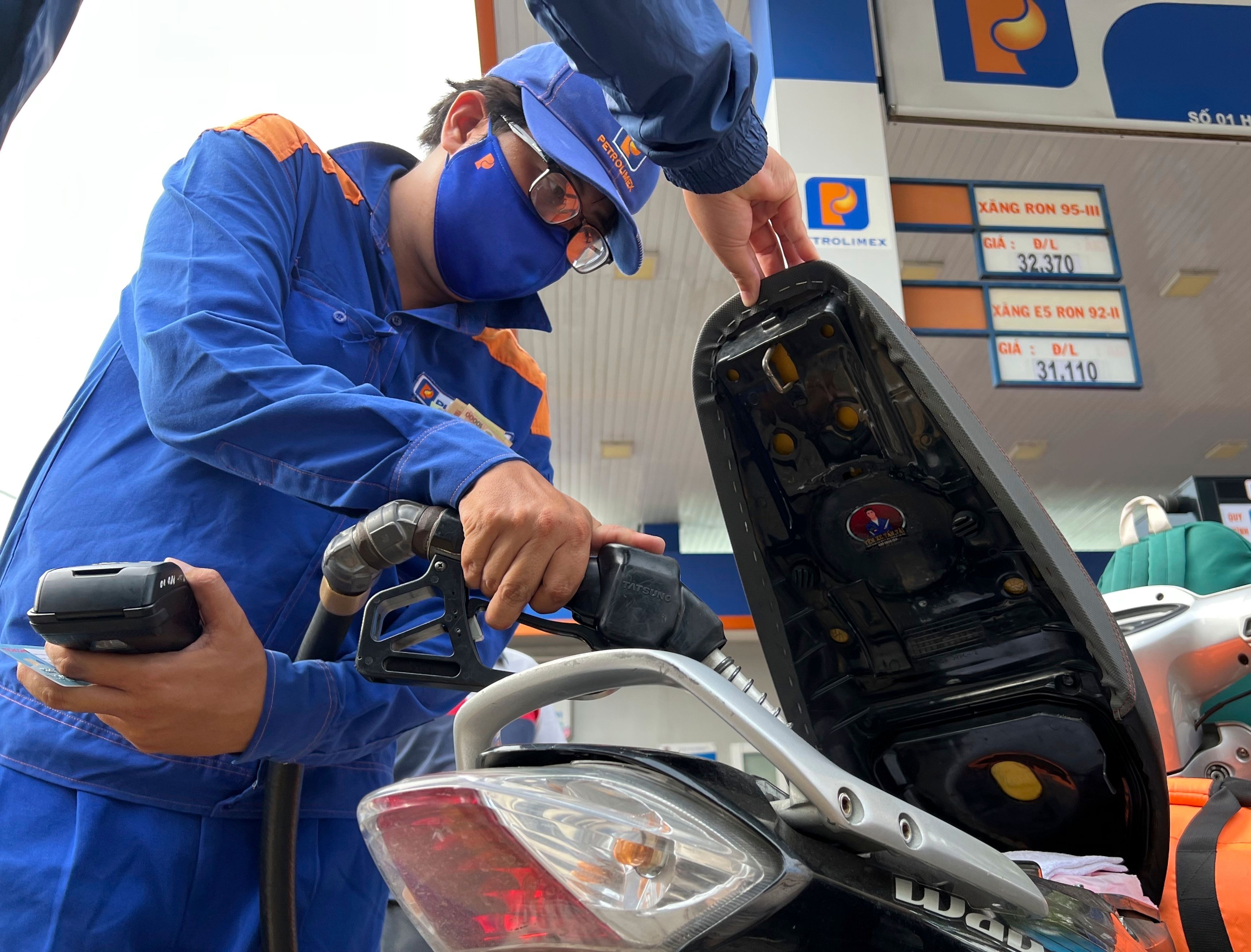 An attendant pumps gas into a motorcycle in Hanoi, Vietnam Sunday, June 19, 2022. Across the globe, drivers are rethinking their habits and personal finances amid skyrocketing prices for gasoline and diesel, fueled by Russia's war in Ukraine and the global rebound from the COVID-19 pandemic. Energy prices are a key driver of inflation that is rising worldwide and making the cost of living more expensive.(AP Photo/Hau Dinh)