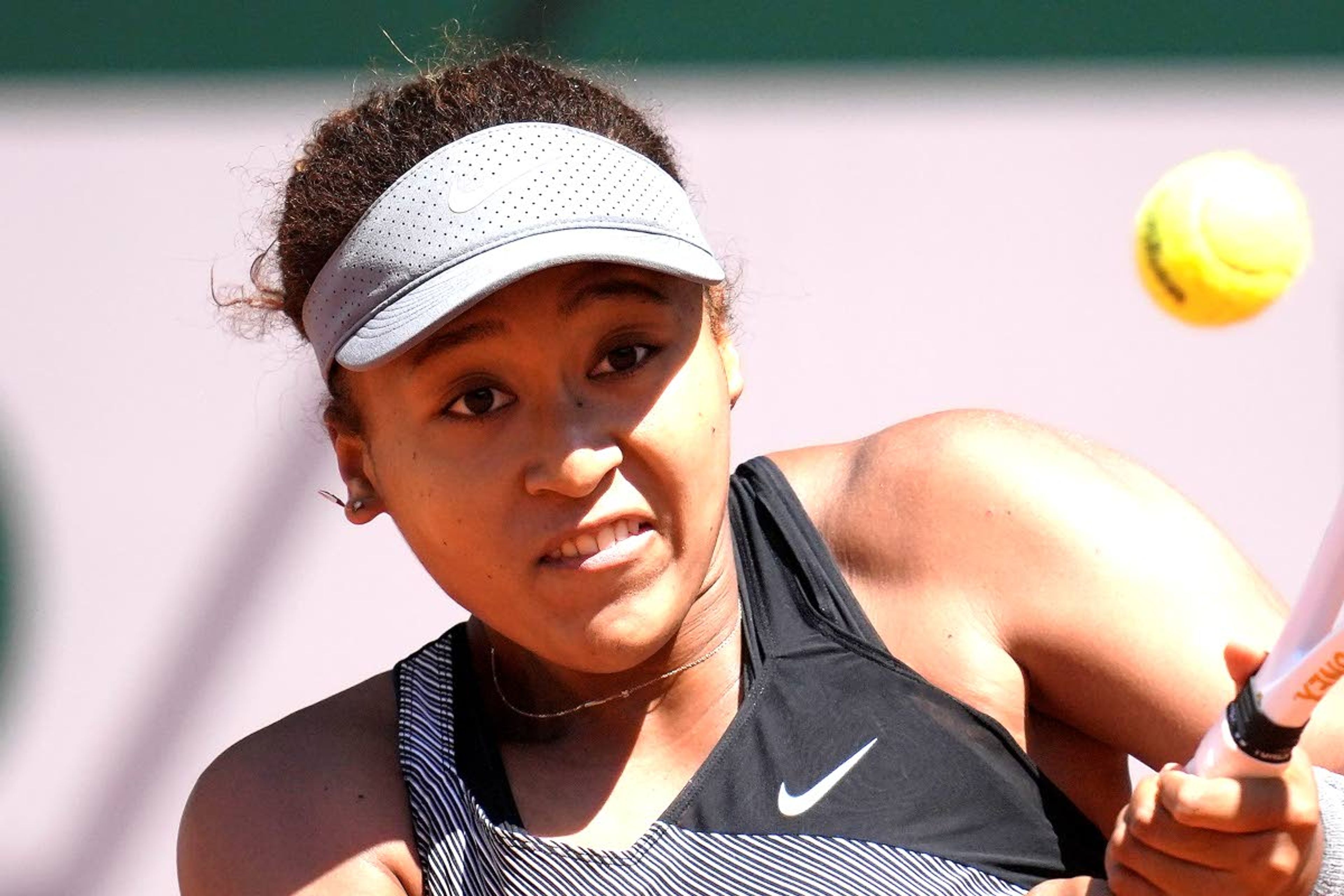 FILE - Japan's Naomi Osaka returns the ball to Romania's Patricia Maria Tig during their first round match of the French open tennis tournament at the Roland Garros stadium in Paris, in this Sunday, May 30, 2021, file photo. Naomi Osaka withdrew from the French Open on Monday, May 31, and wrote on Twitter that she would be taking a break from competition, a dramatic turn of events for a four-time Grand Slam champion who said she has "suffered long bouts of depression."(AP Photo/Christophe Ena, File)