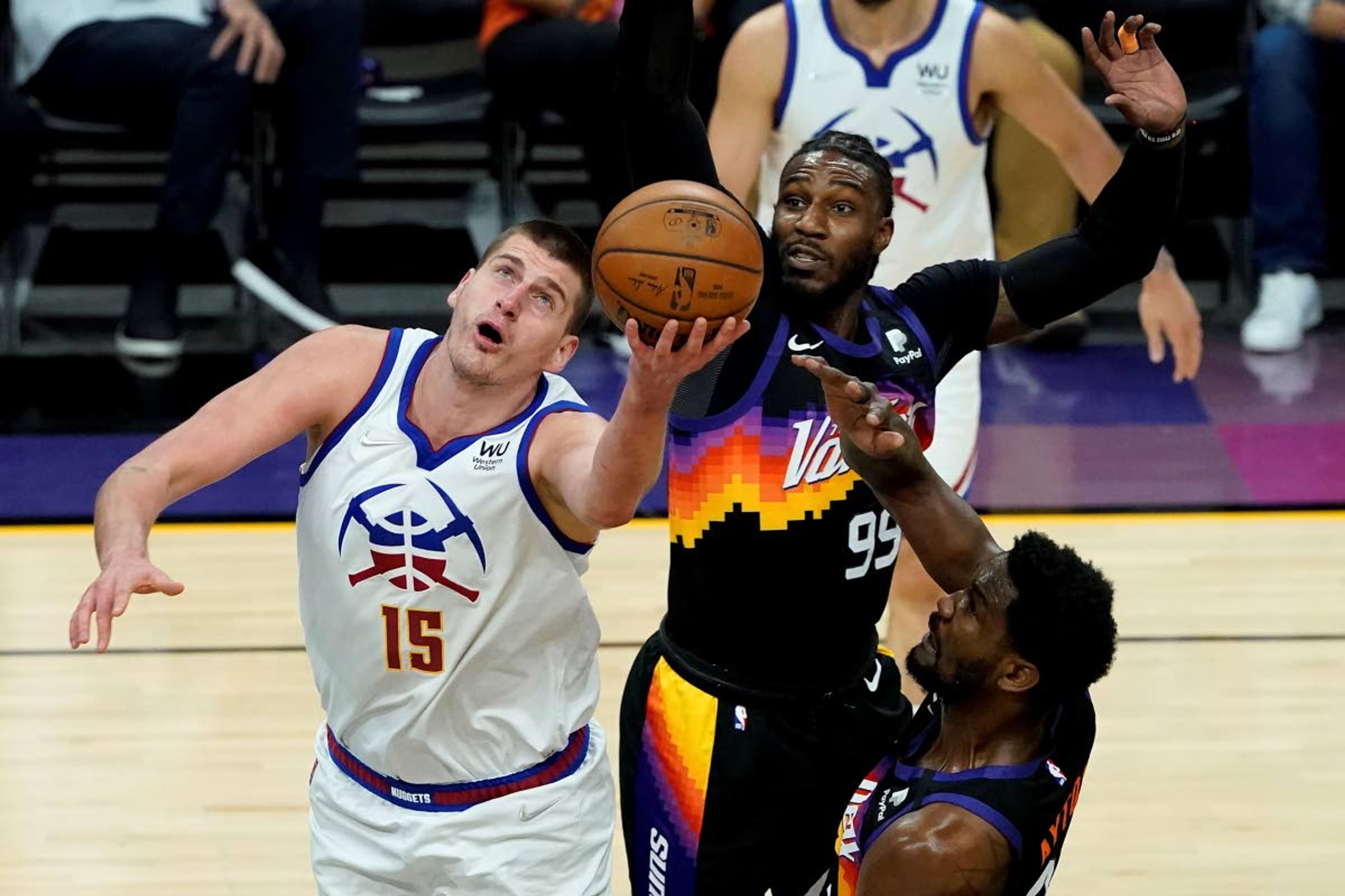 Denver Nuggets center Nikola Jokic (15) shoots as Phoenix Suns forward Jae Crowder (99) defends during the first half of Game 2 of an NBA basketball second-round playoff series, Wednesday, June 9, 2021, in Phoenix. (AP Photo/Matt York)