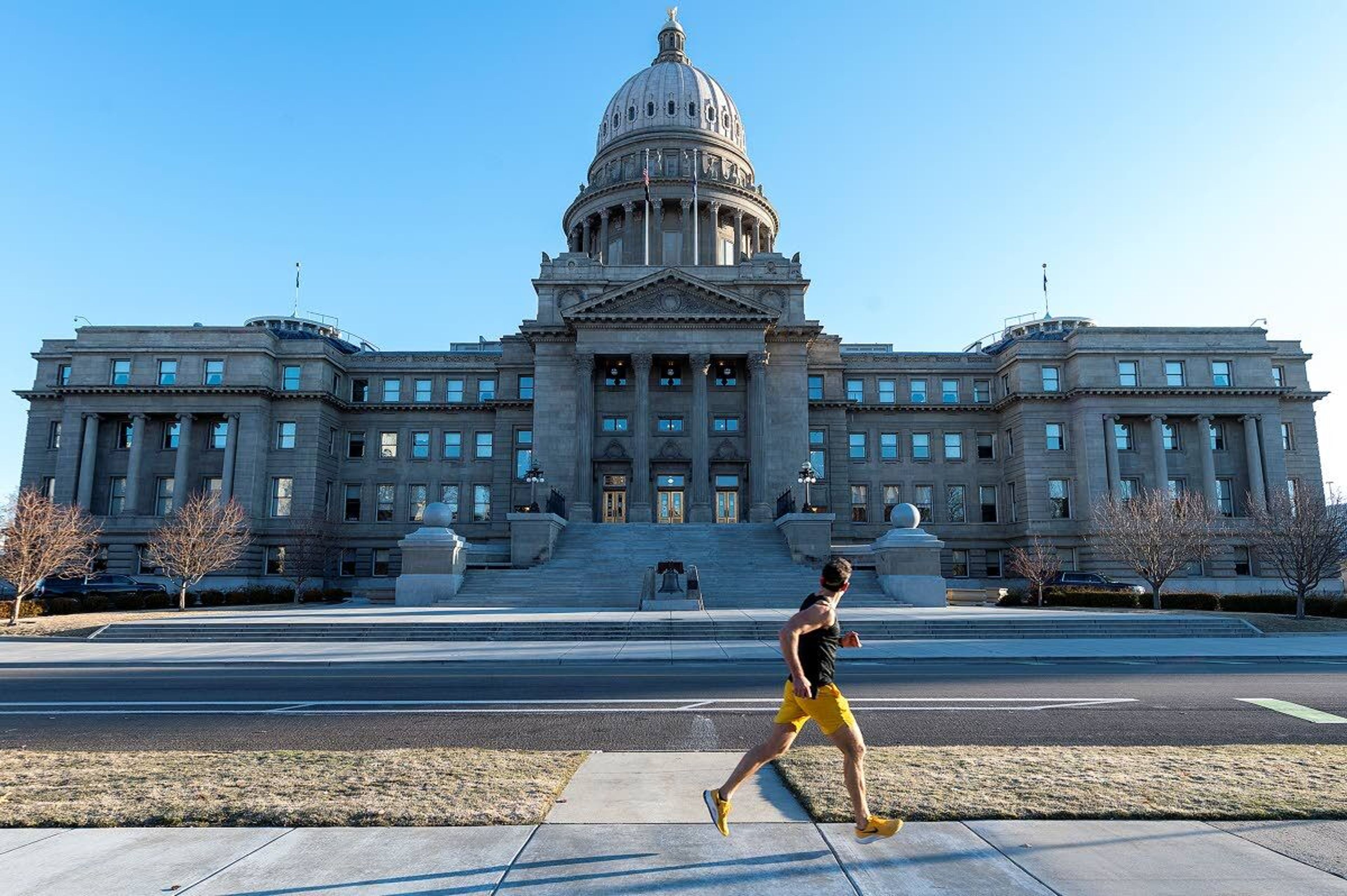 A man runs along West Jefferson Street past the Idaho Capitol Building in Boise in this file photo.