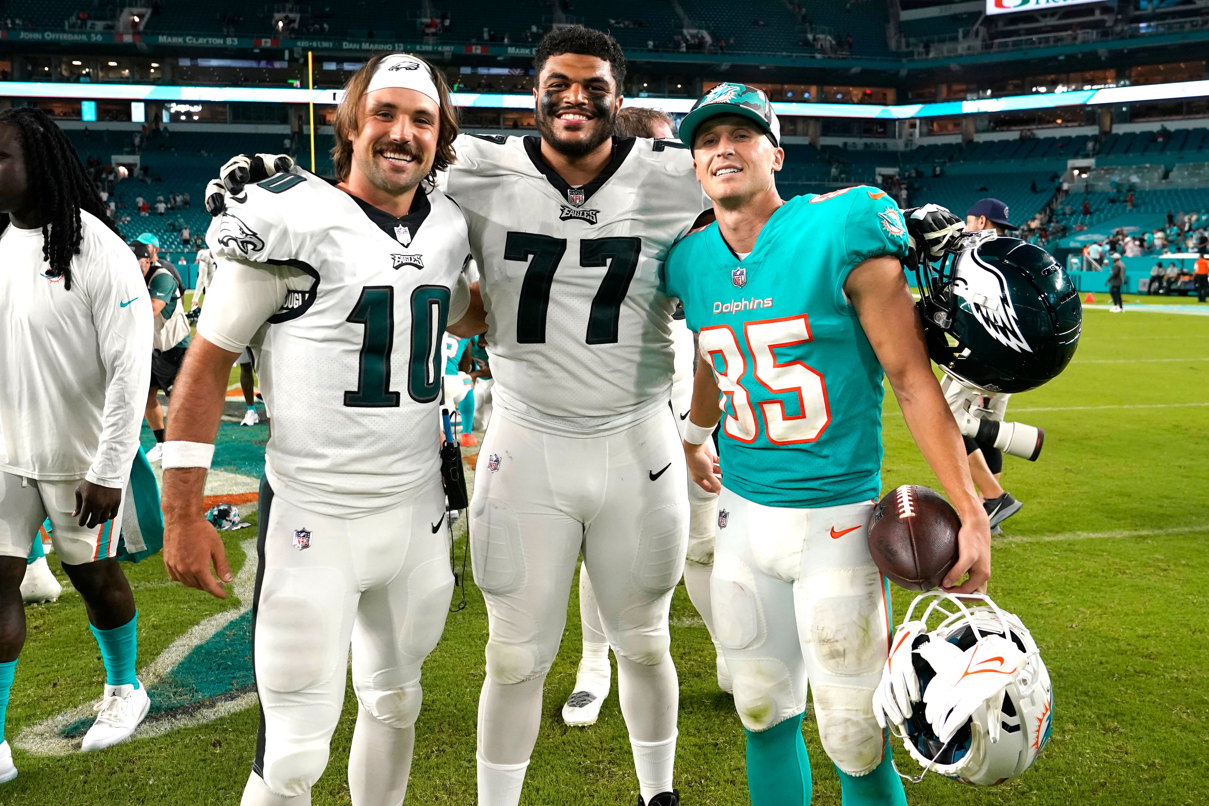 Philadelphia Eagles quarterback Gardner Minshew (10), offensive tackle Andre Dillard (77) and Miami Dolphins wide receiver River Cracraft (85) pose for a photograph after a NFL preseason football game, Saturday, Aug. 27, 2022, in Miami Gardens, Fla. (AP Photo/Lynne Sladky)