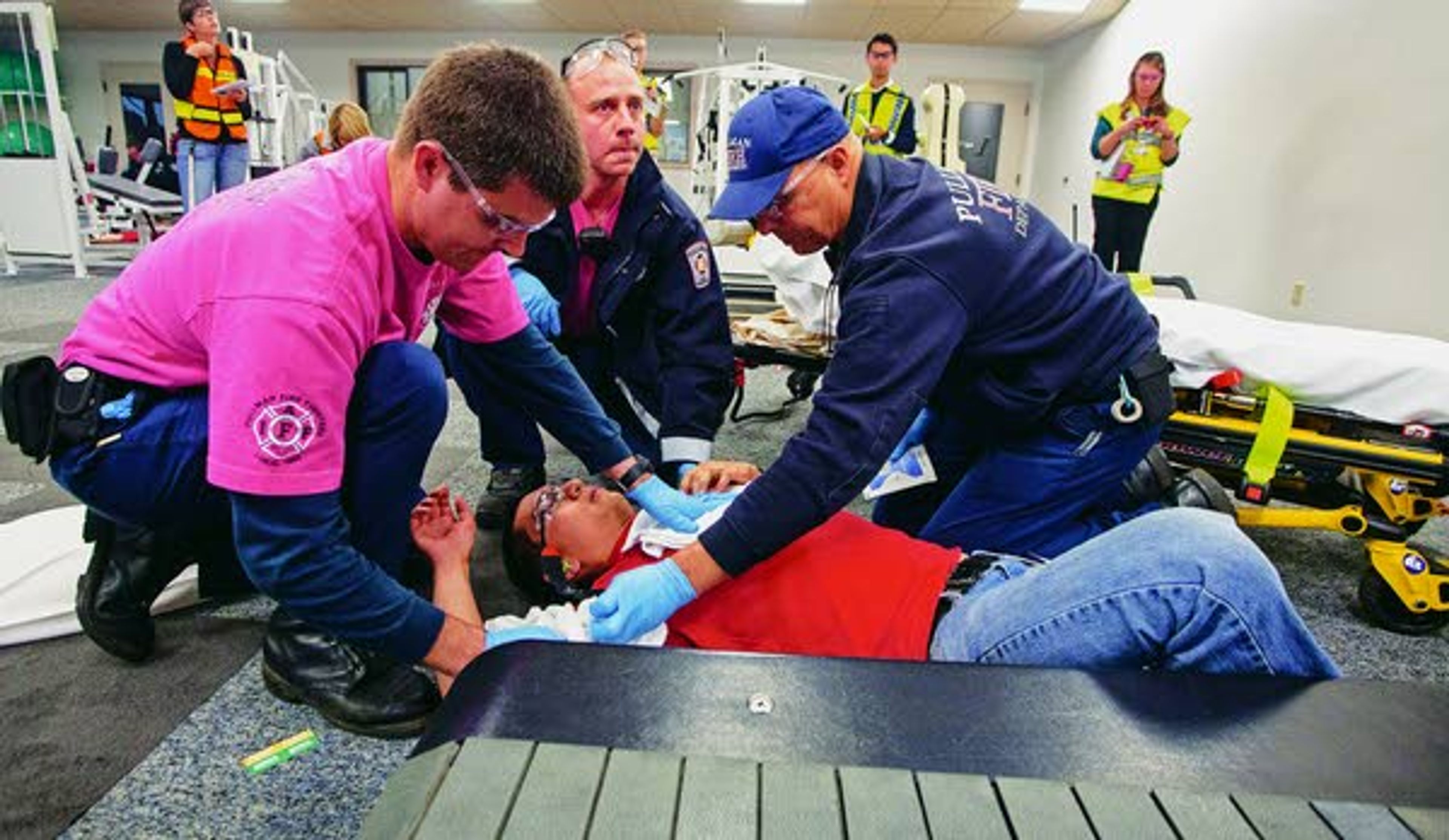 Pullman Fire Department firefighters (left to right) Ben Gecas, Chris Koeppel and Mark Sugden work on a "gunshot victim" with a simulated chest wound who was "shot" while on a treadmill during an active shooter response drill run by the Pullman Police Department on Sunday at Summit Therapy in Pullman.