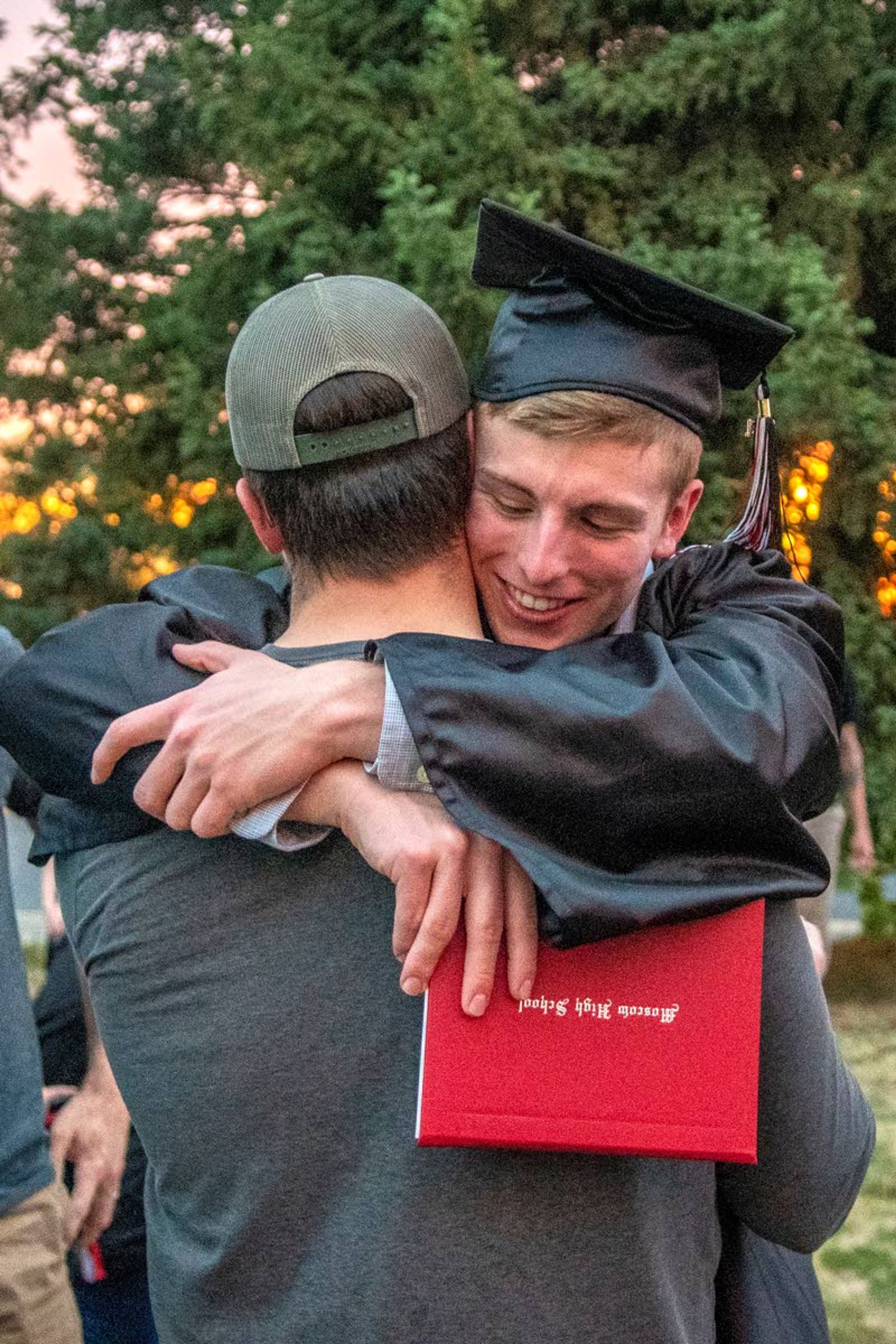 Graduate Joe Colter hugs his brother, Dan Colter, after completing Moscow High School’s Class of 2021 graduation commencement at the University of Idaho’s Kibbie Dome on Friday night.