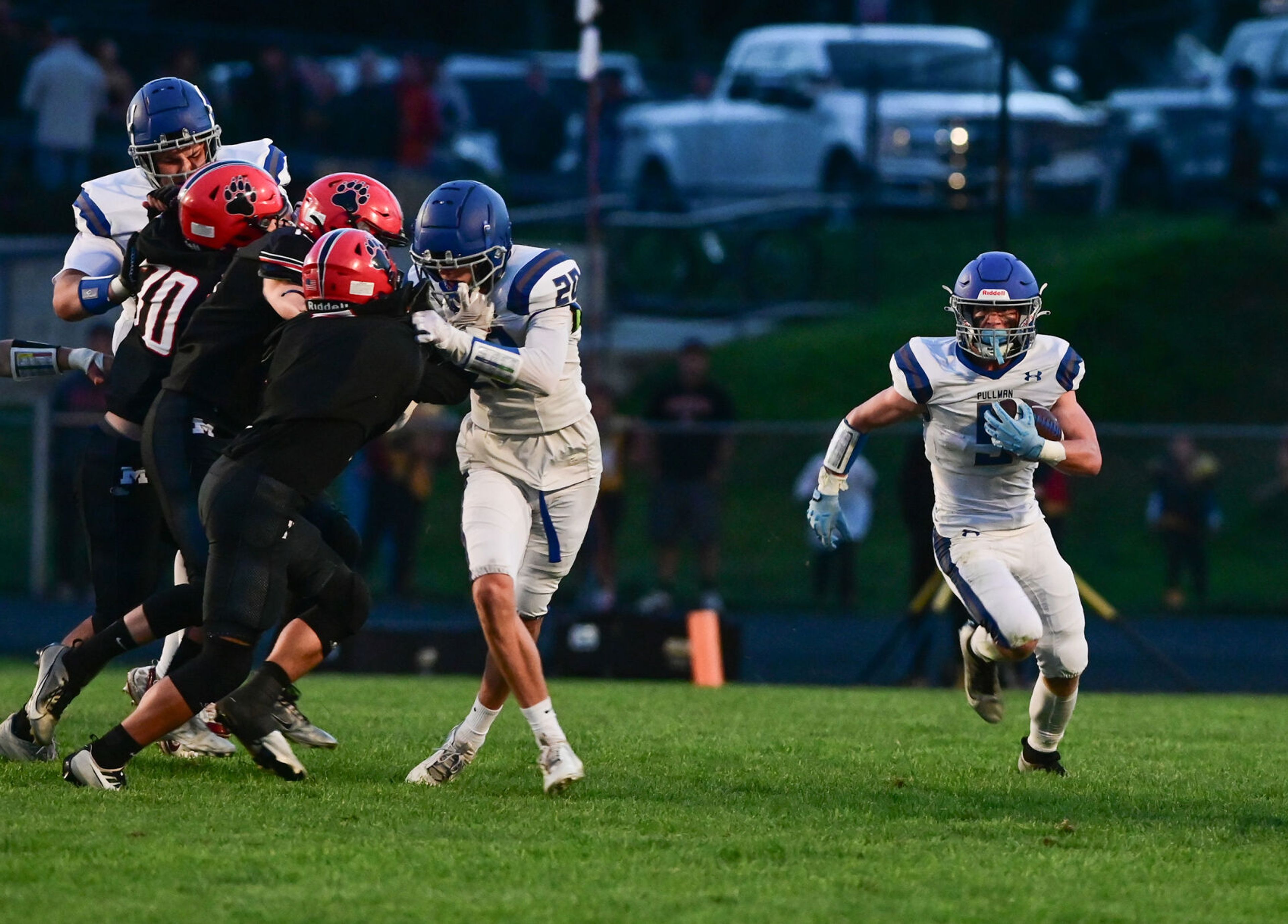 Pullman running back Brady Coulter carries the ball downfield as Pullman players and Moscow players collide Friday in Moscow.