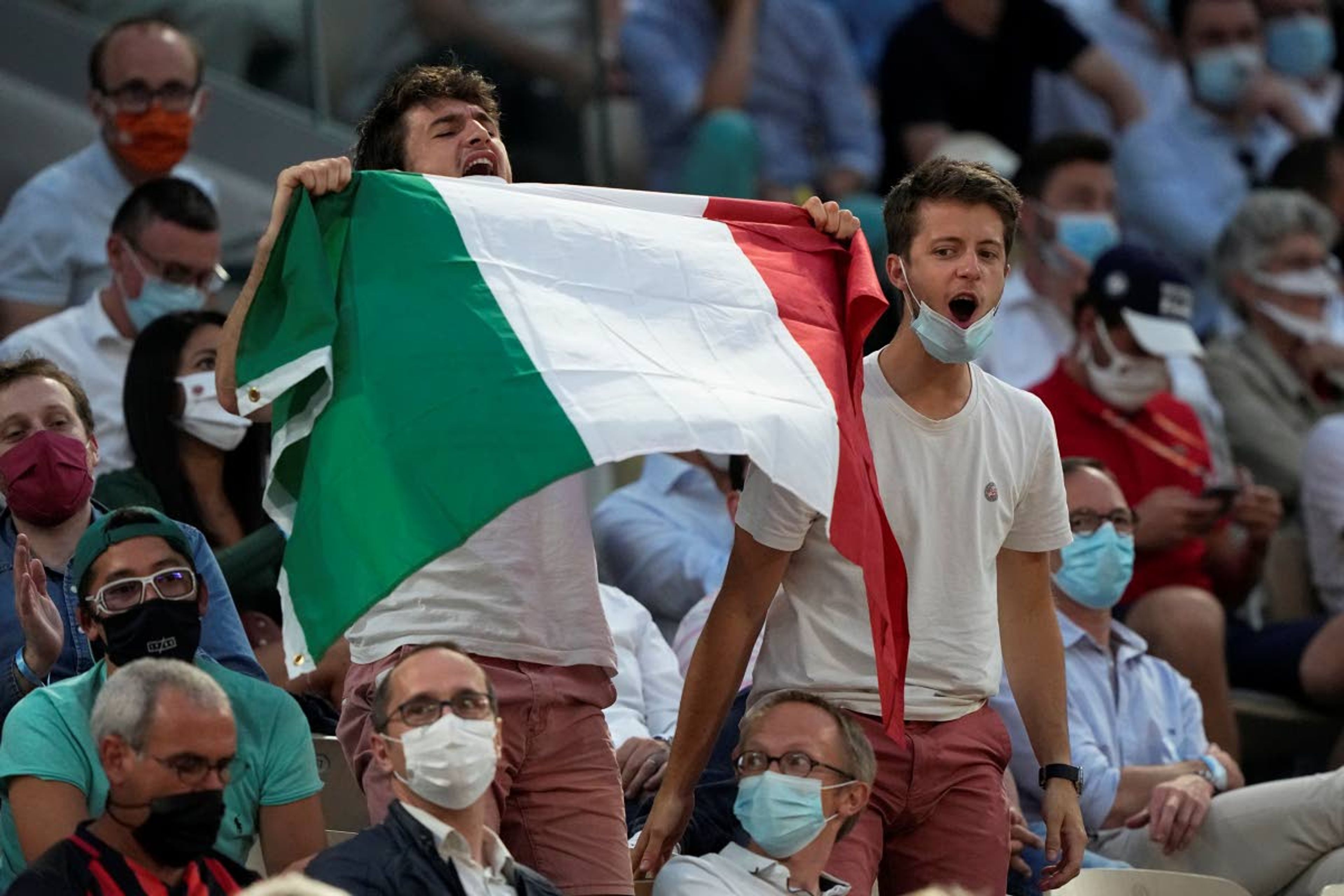 Italian tennis lovers support Italy's Matteo Berrettini playing Serbia's Novak Djokovic during their quarterfinal match of the French Open tennis tournament at the Roland Garros stadium Wednesday, June 9, 2021 in Paris. (AP Photo/Michel Euler)