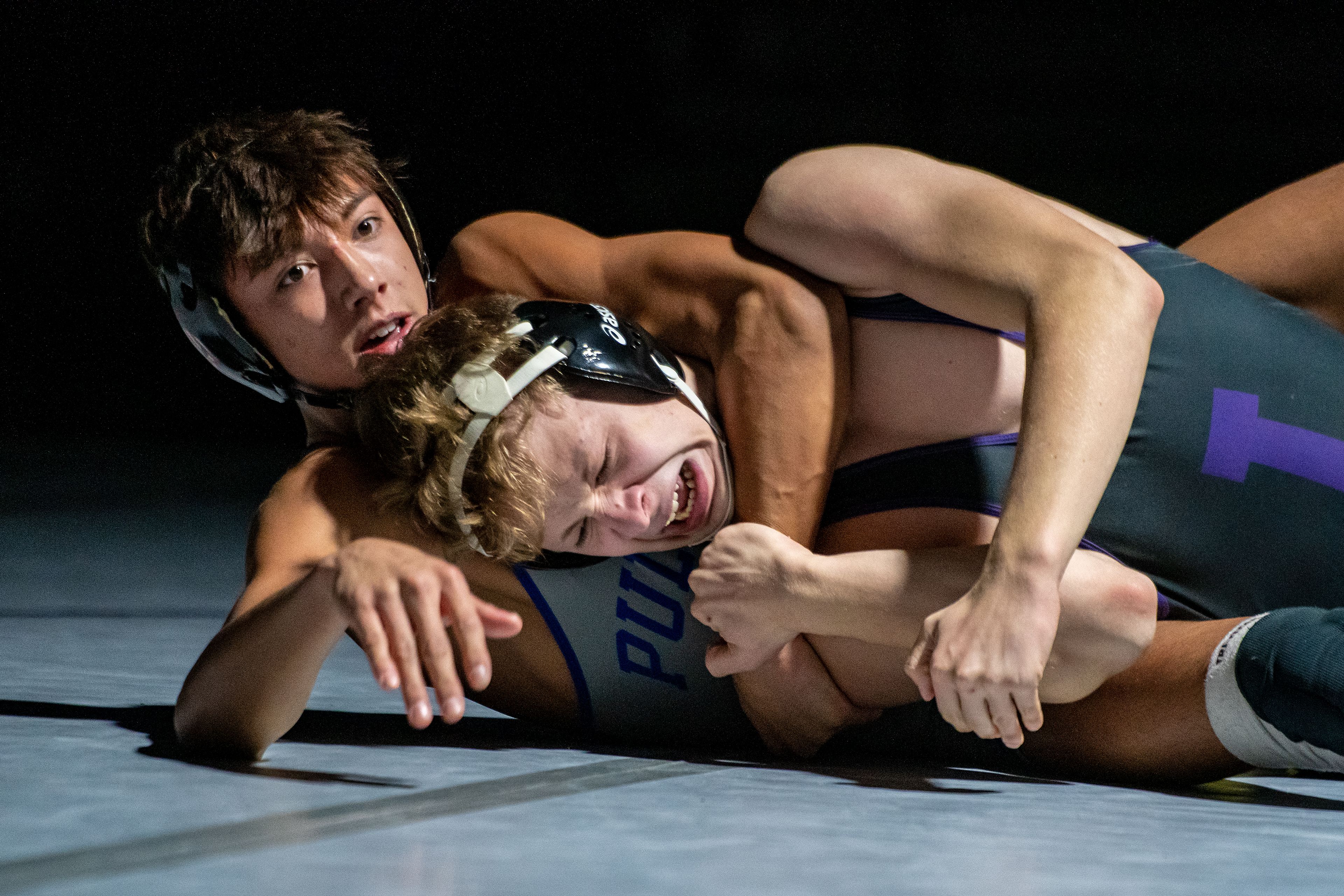 Pullman’s Israel Acosta, left, grapples with Lewiston’s Drew Dammon on Tuesday in the 145-pound weight class during a varsity wrestling match at Lewiston High.