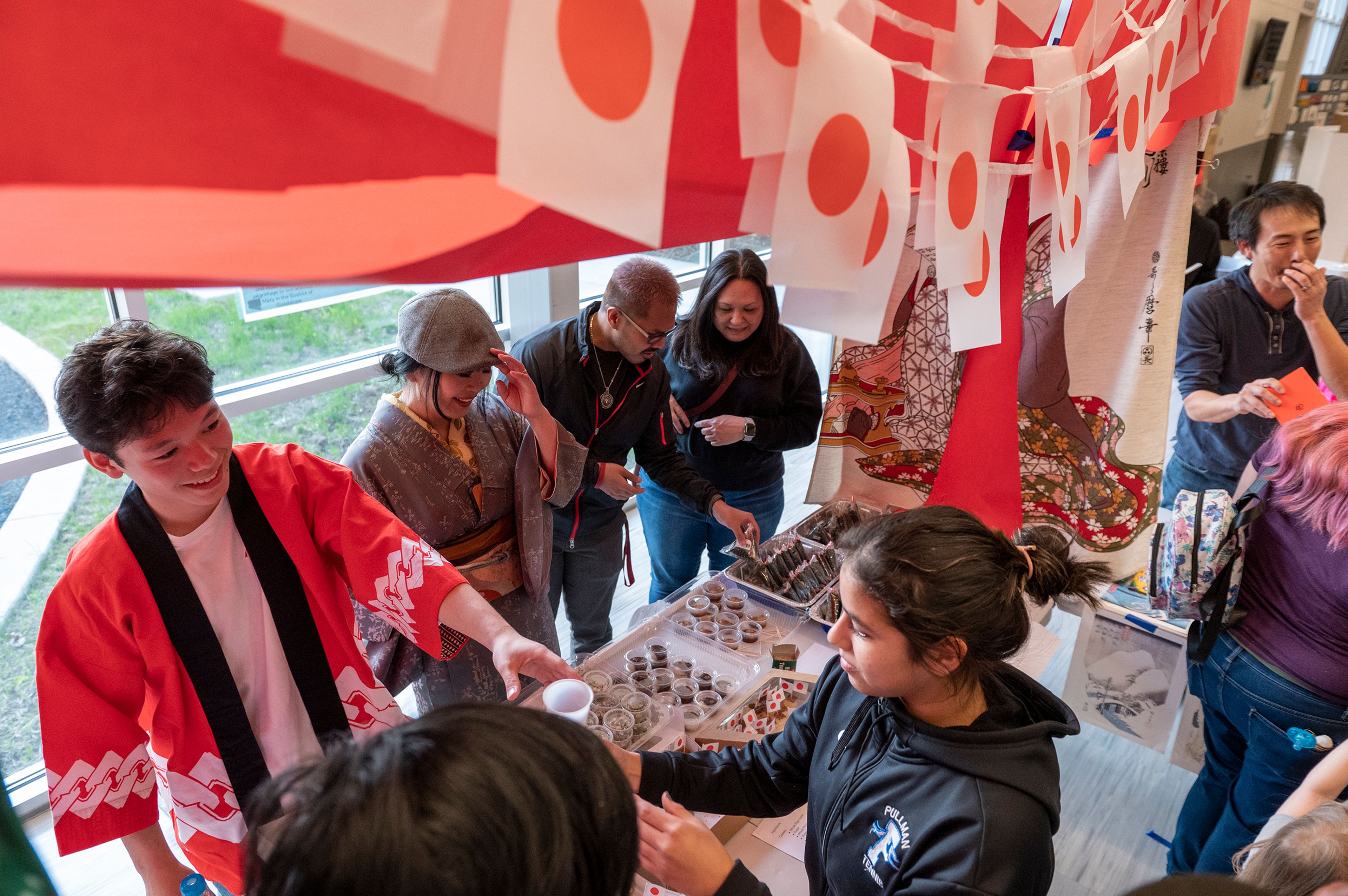 People line up to taste Japanese cuisine Friday at Pullman High School’s multicultural night.