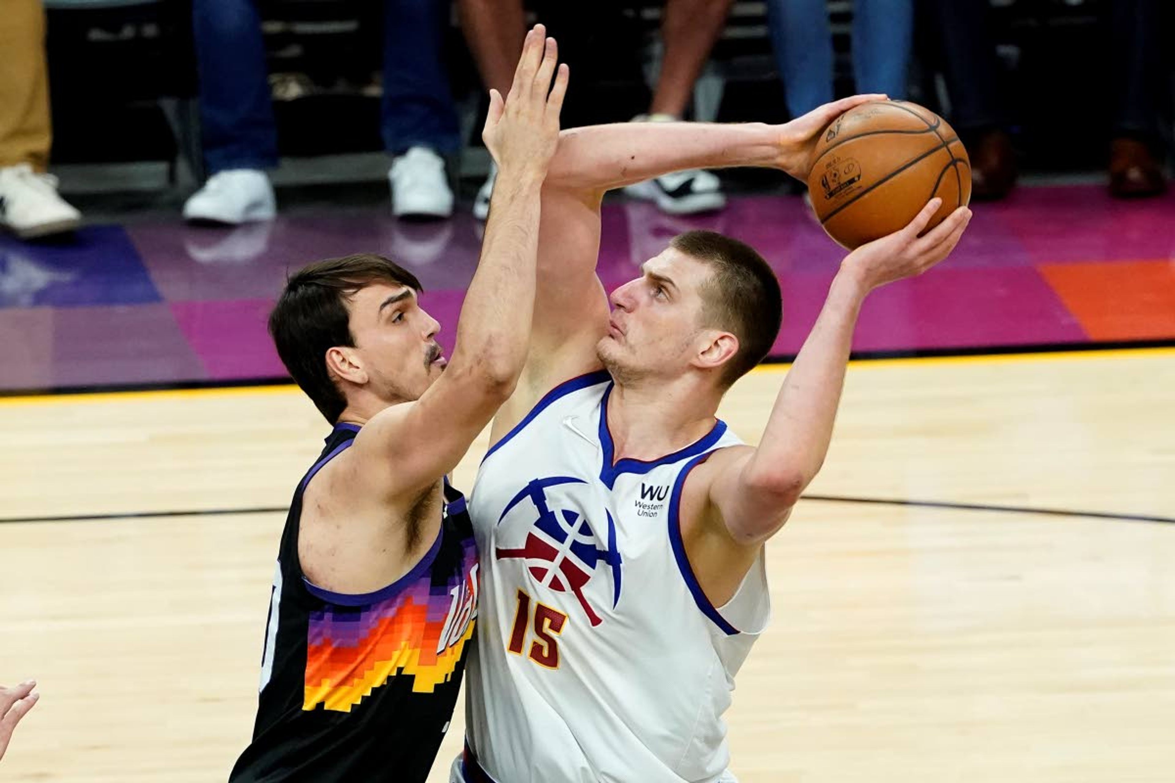 Denver Nuggets center Nikola Jokic (15) shoots as Phoenix Suns forward Dario Saric defends during the first half of Game 2 of an NBA basketball second-round playoff series, Wednesday, June 9, 2021, in Phoenix. (AP Photo/Matt York)