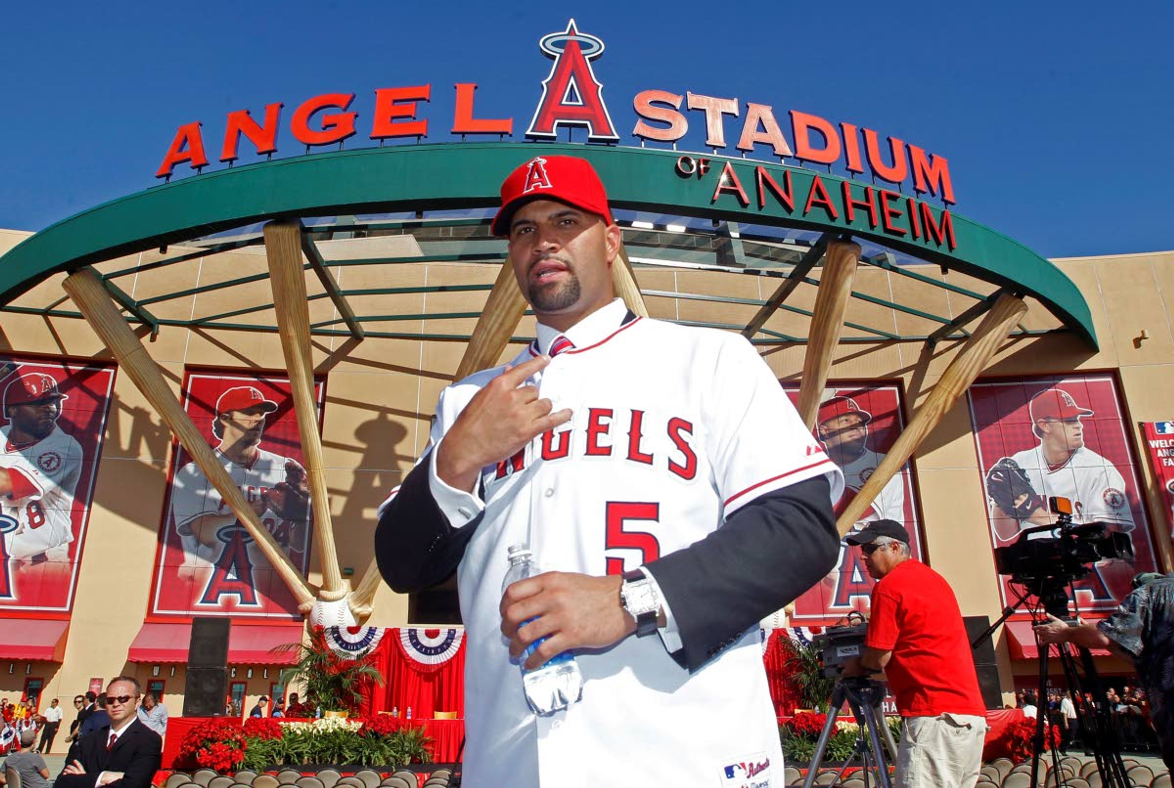 FILE - In this Dec. 10, 2011, file photo, Los Angeles Angels' Albert Pujols wears his new jersey after a news conference to introduce Pujols and C.J. Wilson (not pictured) as the newest Angels baseball players in Anaheim, Calif. Pujols has been designated for assignment by the Los Angeles Angels, abruptly ending the 41-year-old superstar slugger's decade with his second major league team. The Angels announced the move Thursday, May 6, 2021, a day after Pujols wasn't in their lineup for their fourth consecutive loss. (AP Photo/Alex Gallardo, File)