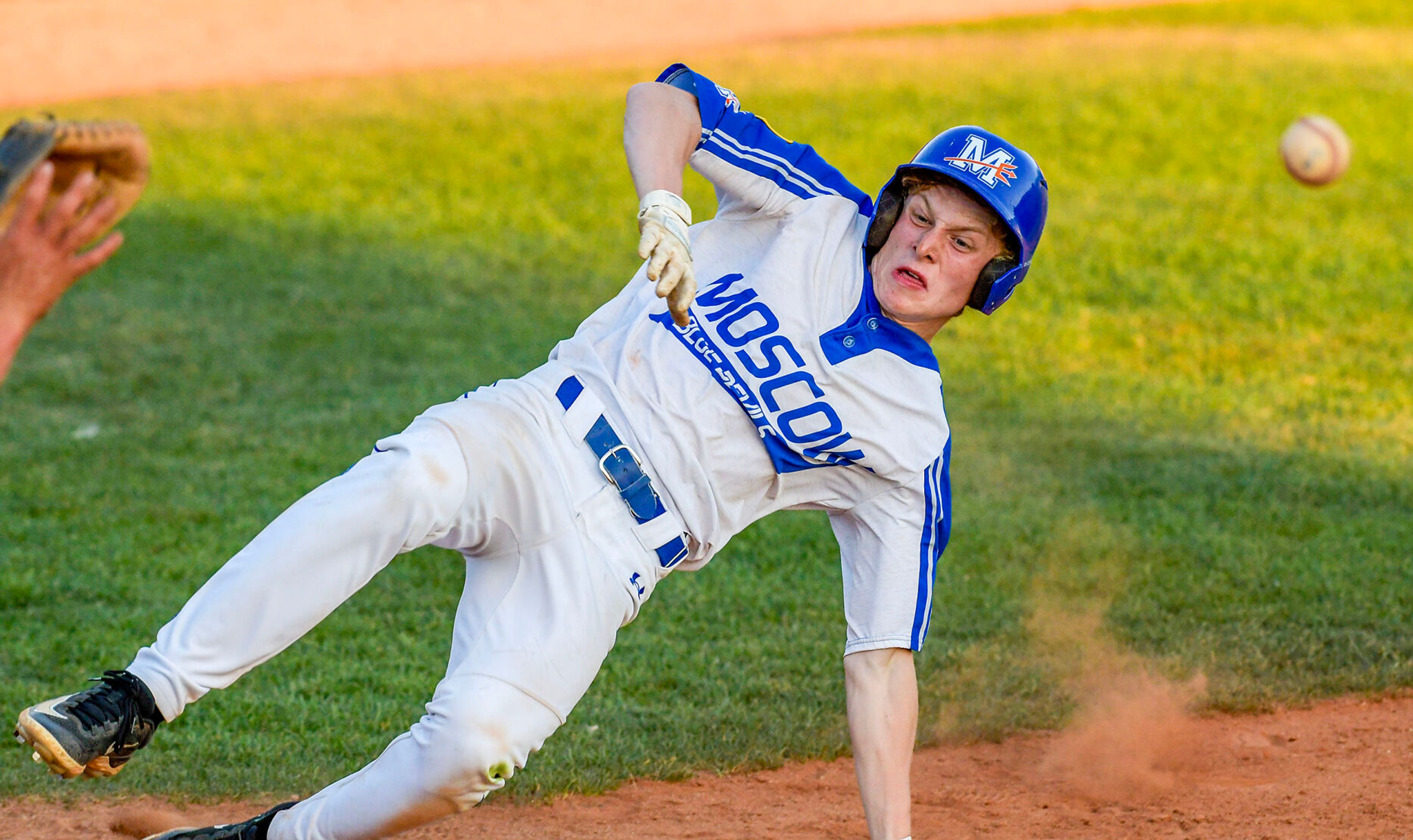 The Moscow Blue Devils' Conner Zollinger slides into home to score against the Lewis-Clark Cubs in a game of the Clancy Ellis Tournament on Saturday at Harris Field in Lewiston.