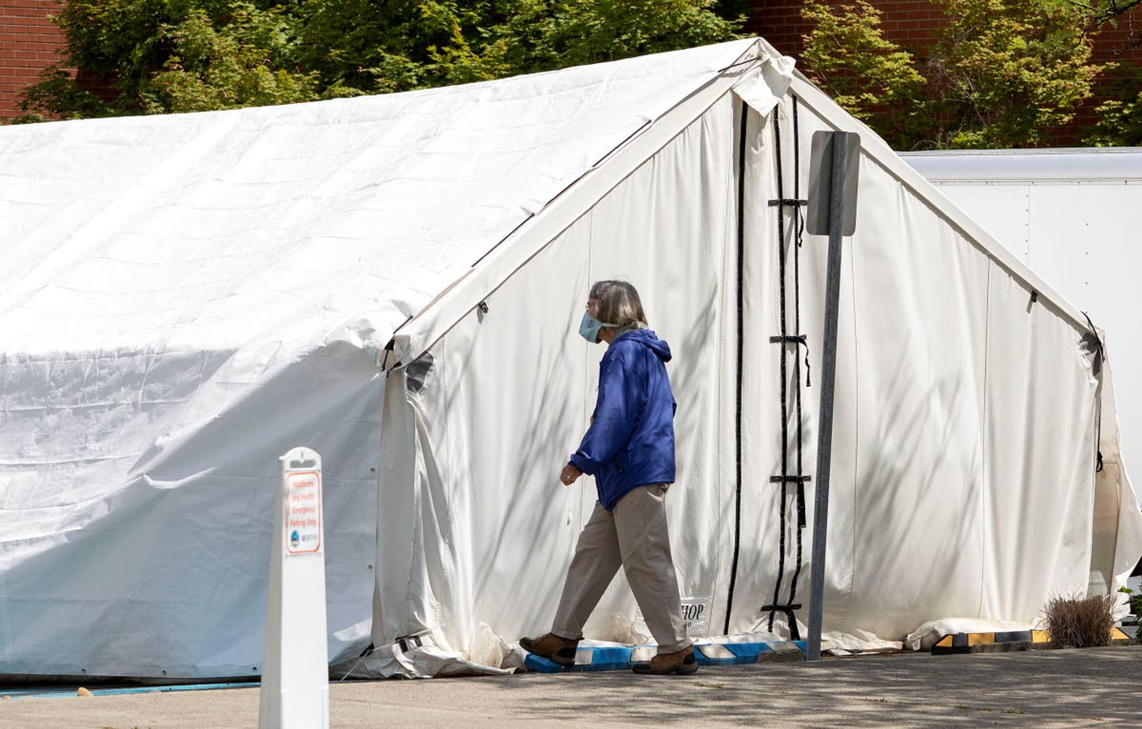 A pedestrian wearing a Facemask walks past a tent used for taking coronavirus tests on Tuesday in a parking lot outside Gritman Medical Center in Moscow.