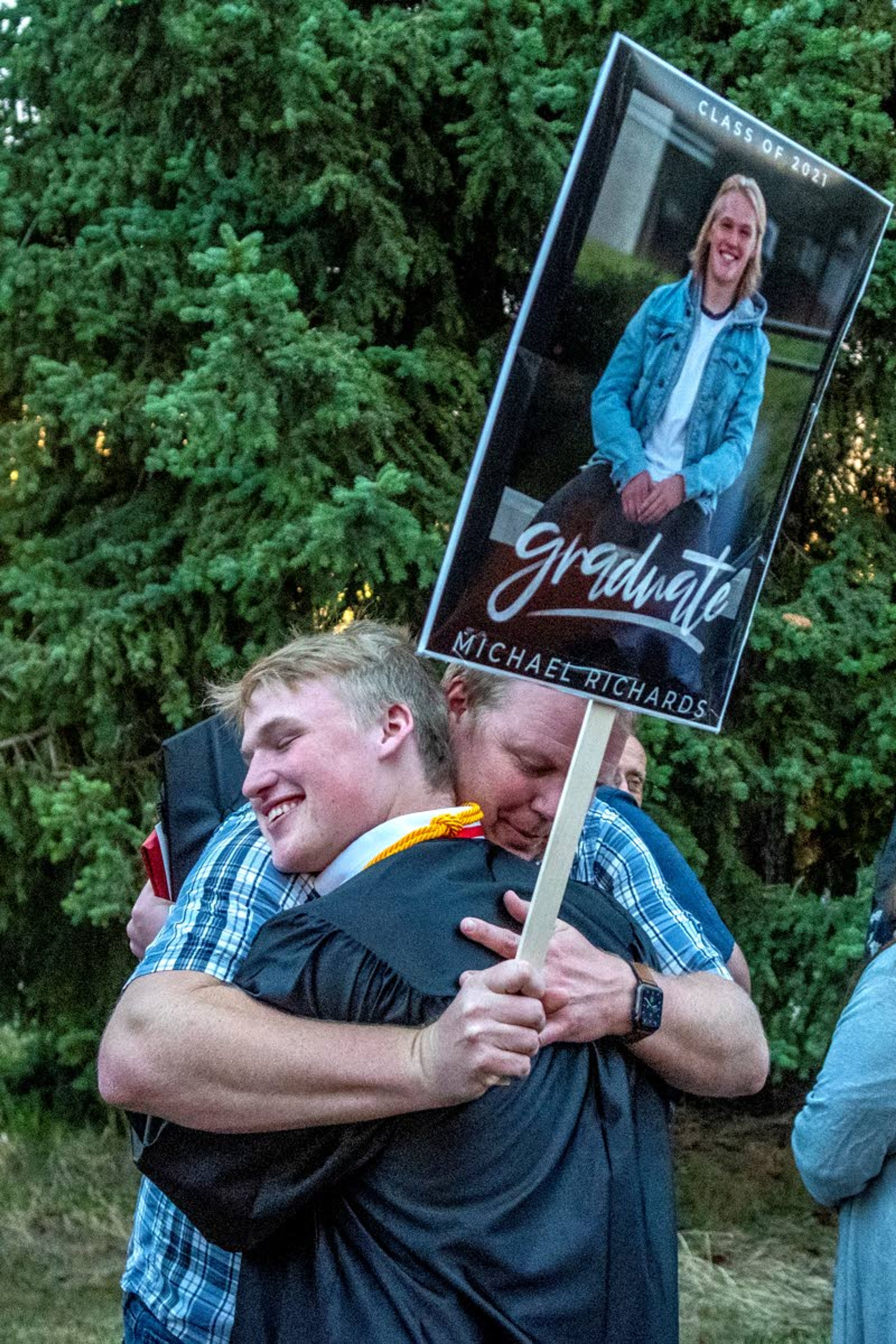 Graduate Michael Richards hugs his father, Shawn Richards, after completing Moscow High School’s Class of 2021 graduation commencement at the University of Idaho’s Kibbie Dome on Friday night.