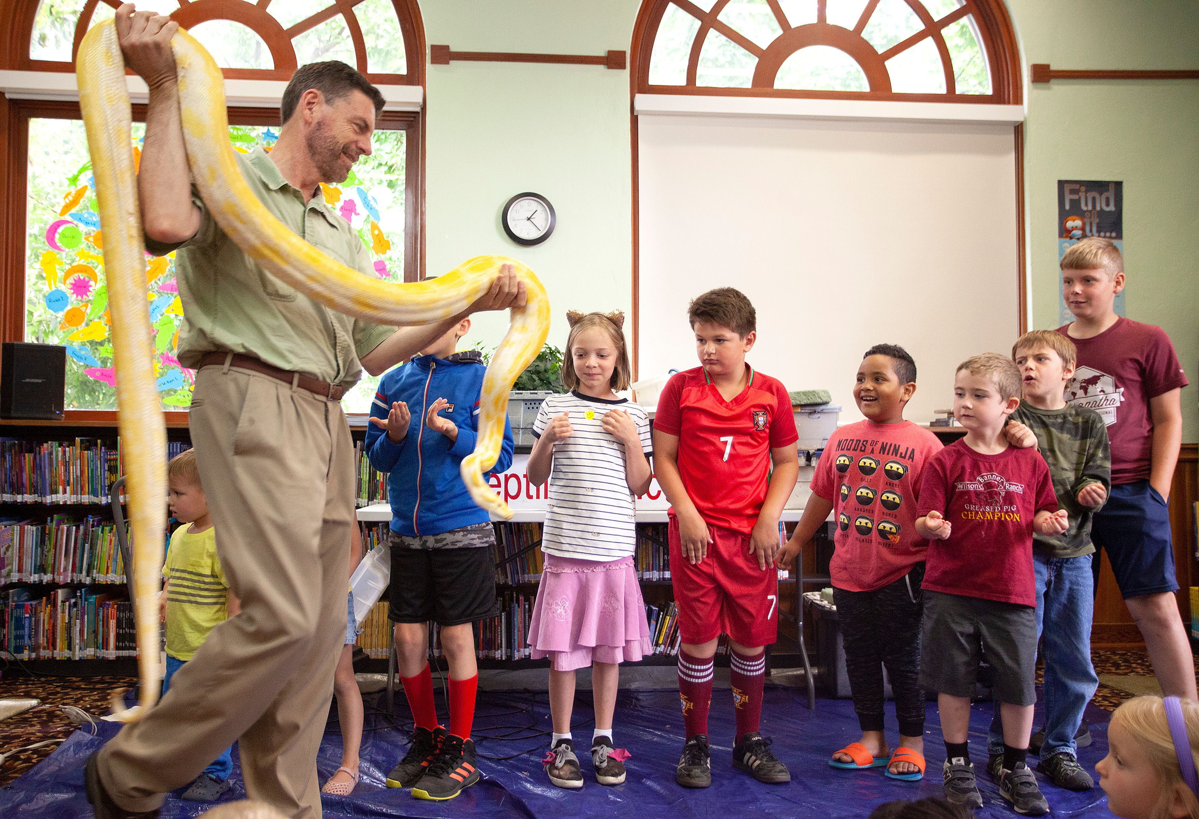 The Reptile Man Scott Petersen lets children hold a python during a presentation on Thursday at the Moscow Public Library.