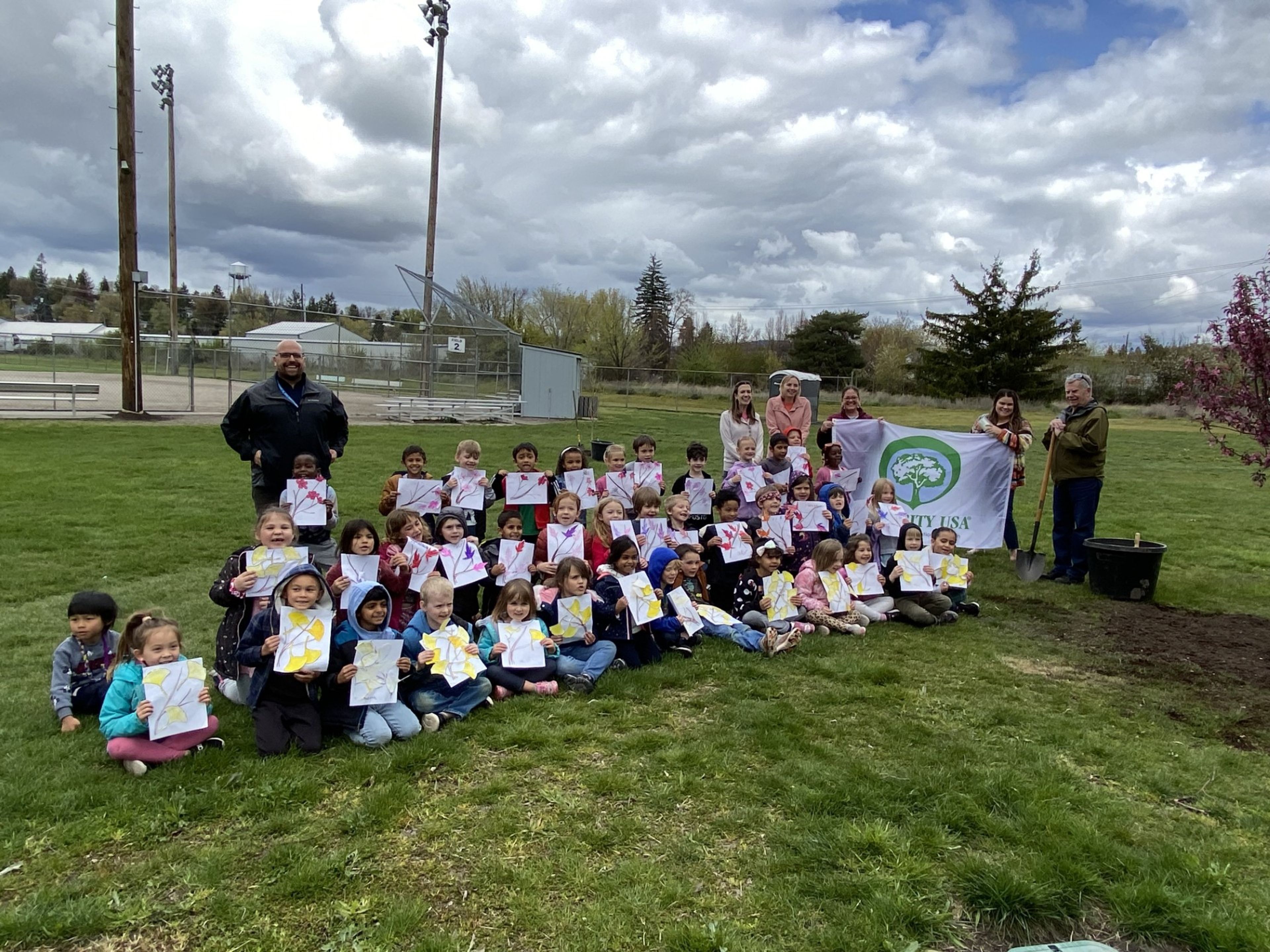 The Moscow Tree Commission and West Park Elementary School kindergarten students, displaying their tree art work, partnered to celebrate Arbor Day with the planting of six trees at Ghormley Park on April 26. Photo submitted by Mary Jo Hamilton