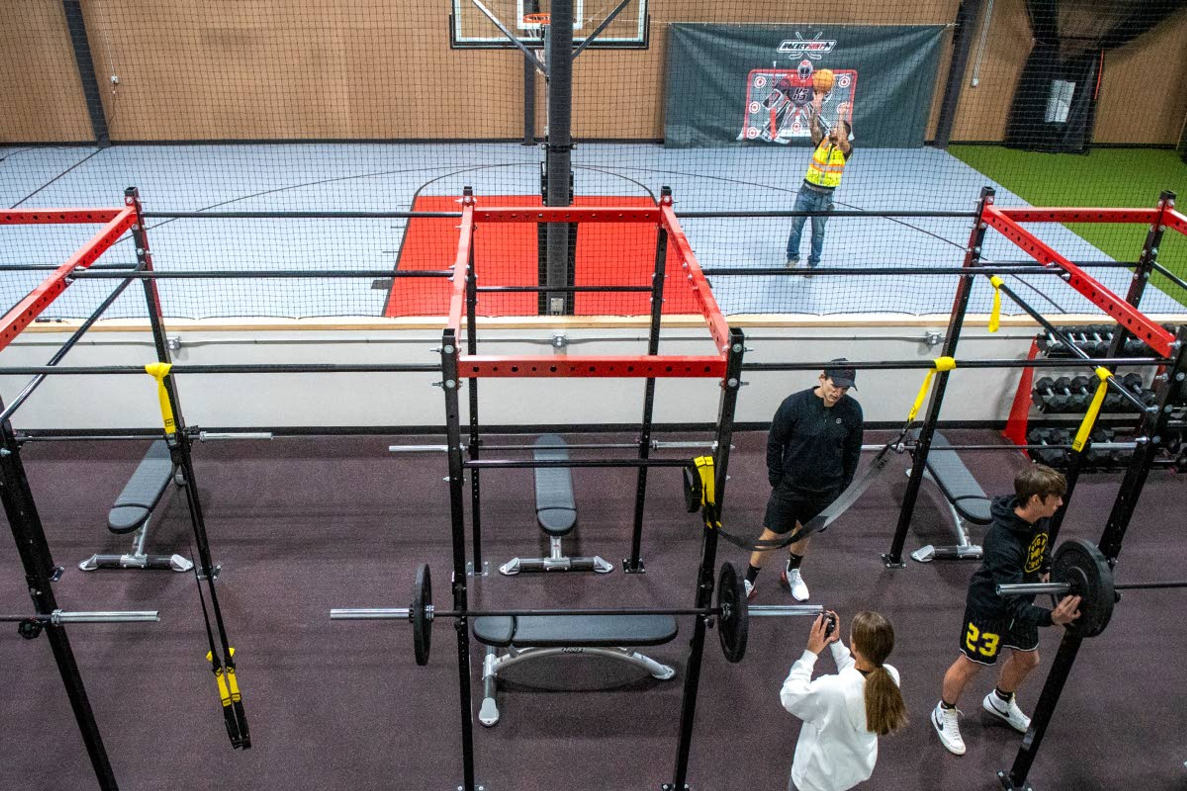 Zach Wilkinson/Daily NewsPaul Cummings shoots around on the basketball court as director of strength and conditioning Travis Seltenreich prepares to work with Kaci Kiben, bottom, and Traiden Cummings on their back squat forms while training at Reactiv Training Center in Moscow on Thursday afternoon.