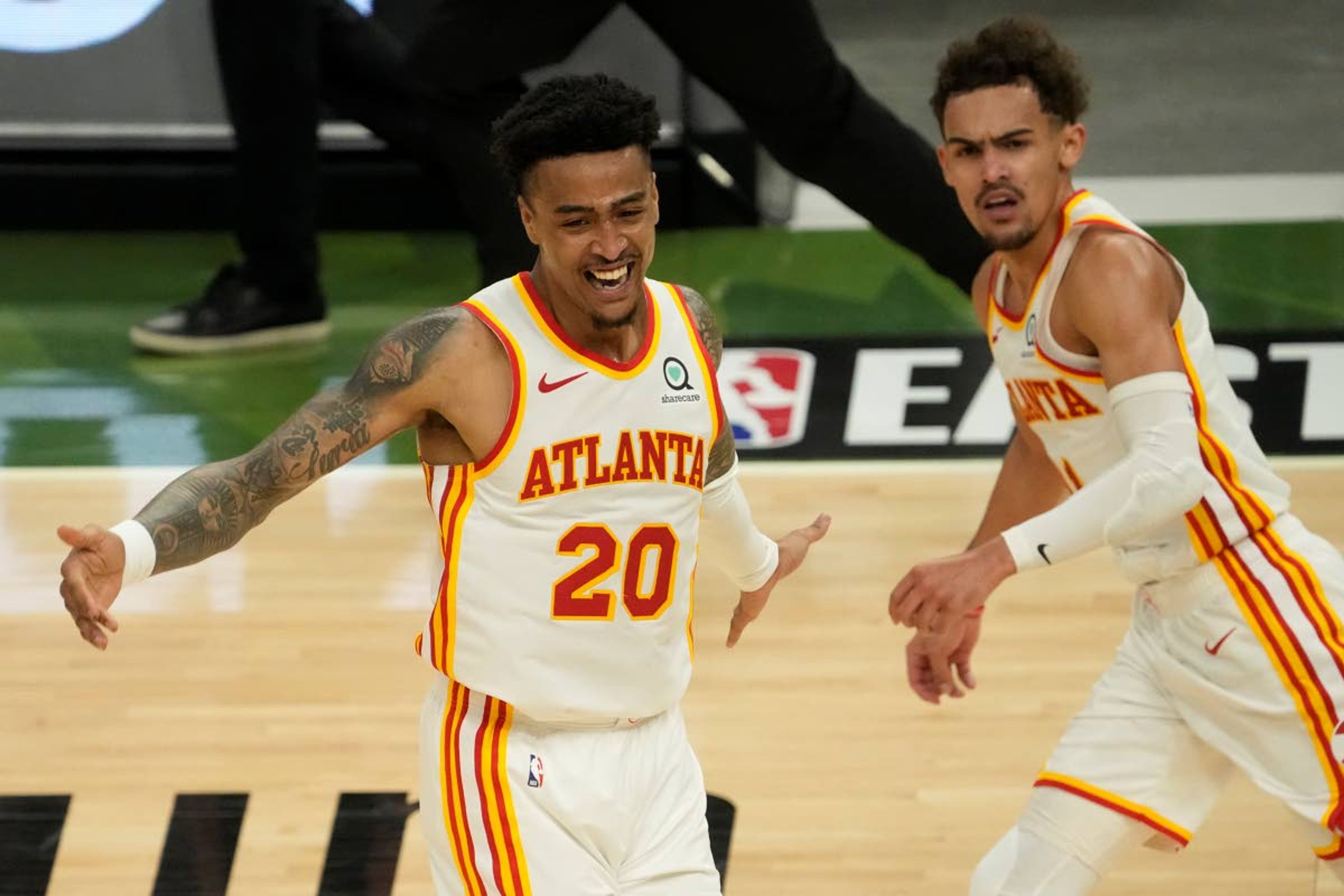 Atlanta Hawks' John Collins reacts after a dunk assisted by Trae Young during the second half of Game 1 of the NBA Eastern Conference basketball finals game against the Milwaukee Bucks Wednesday, June 23, 2021, in Milwaukee. (AP Photo/Morry Gash)