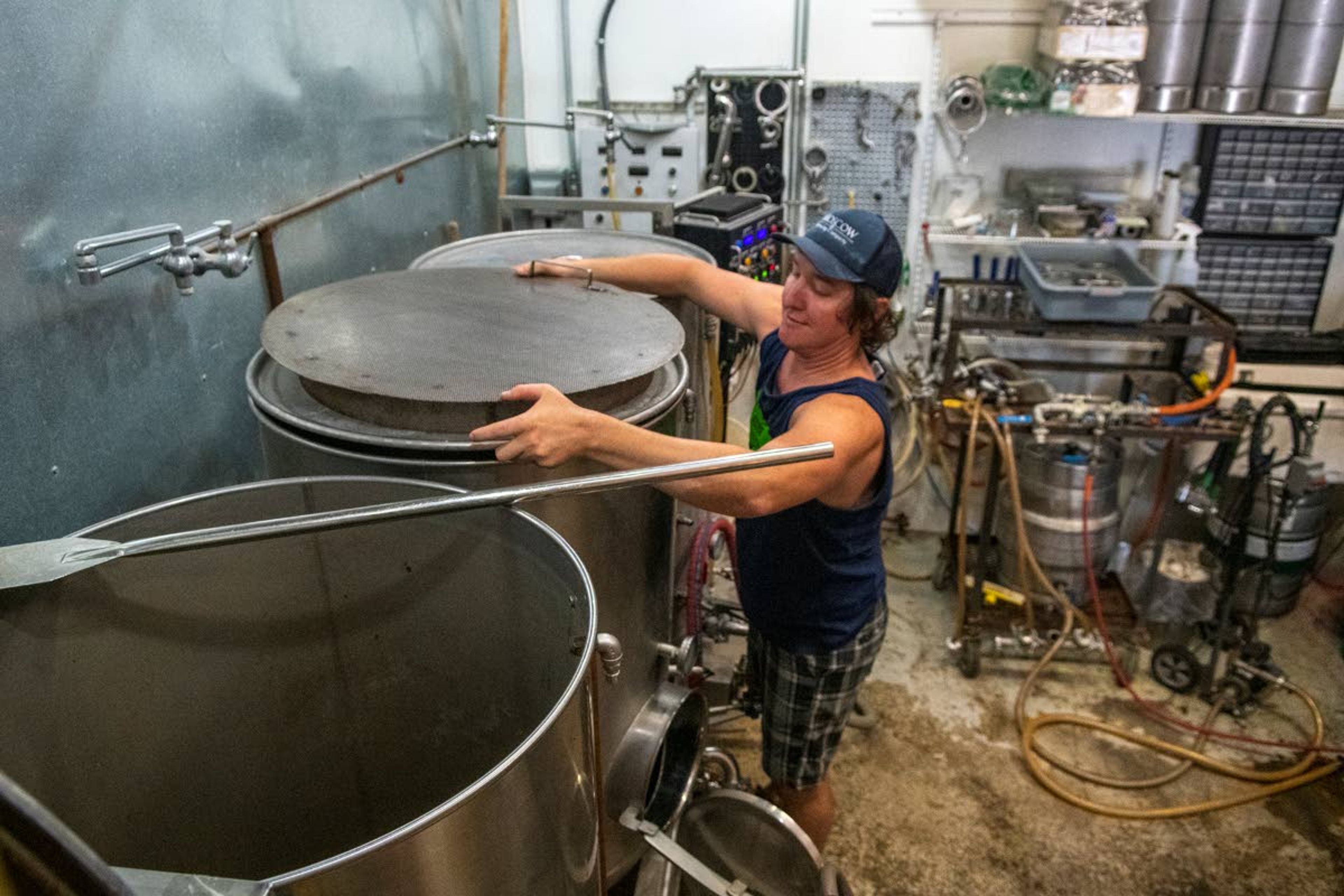 Zach Wilkinson/Daily NewsMoscow Brewing Company owner Aaron Hart examines three of the 125-gallon barrel tanks used to make beer at the brewery.