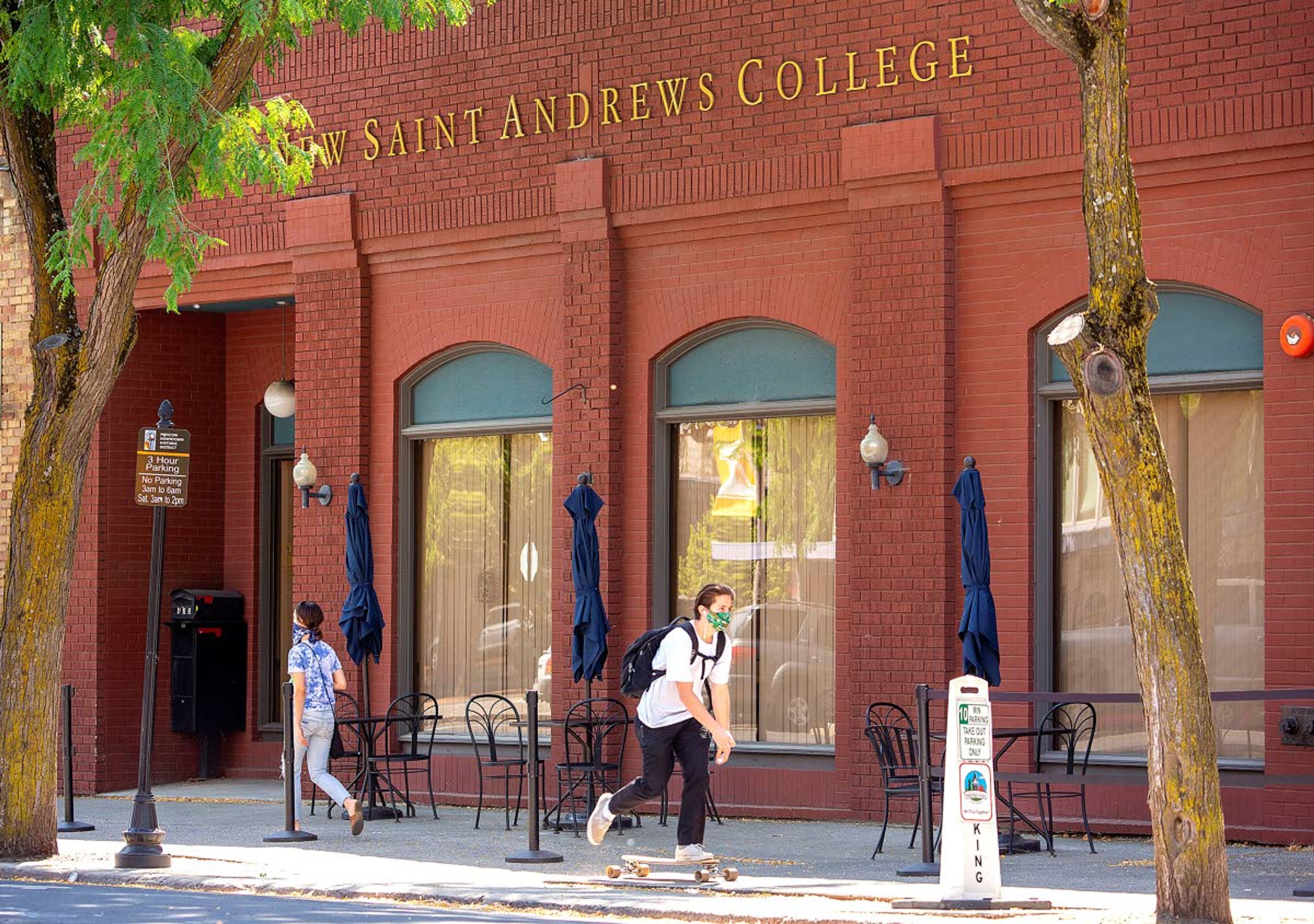 A skateboarder wearing a mask rolls past New Saint Andrews College on Wednesday in Moscow. The college is planning to hold classes in person with social distancing. Students will also be allowed to wear masks if they want.