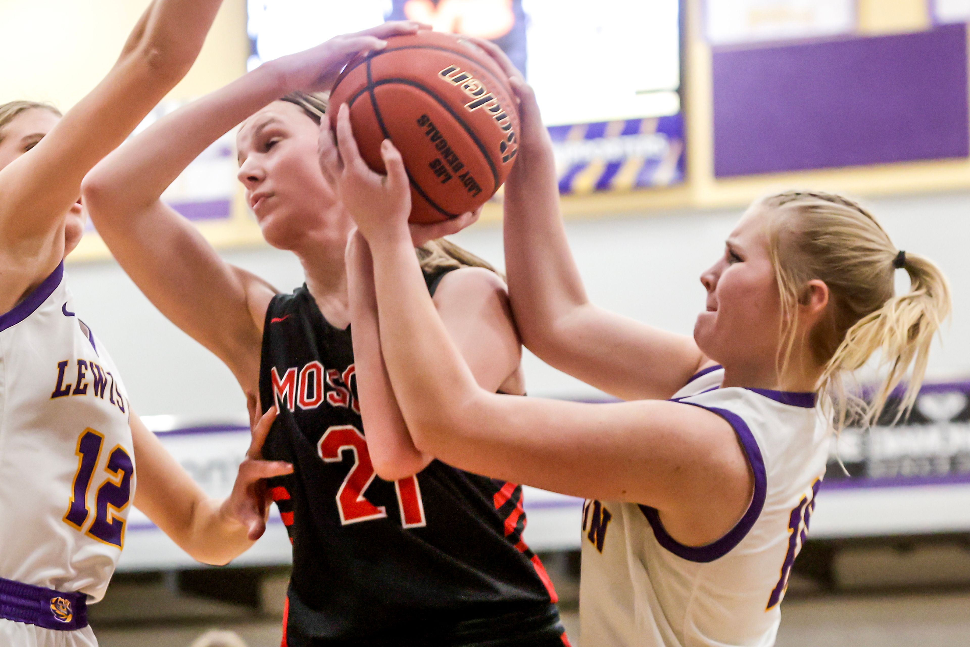 Moscow forward Jacque Williams fights for the ball with Lewiston point guard Bay Delich in Lewiston on Wednesday.