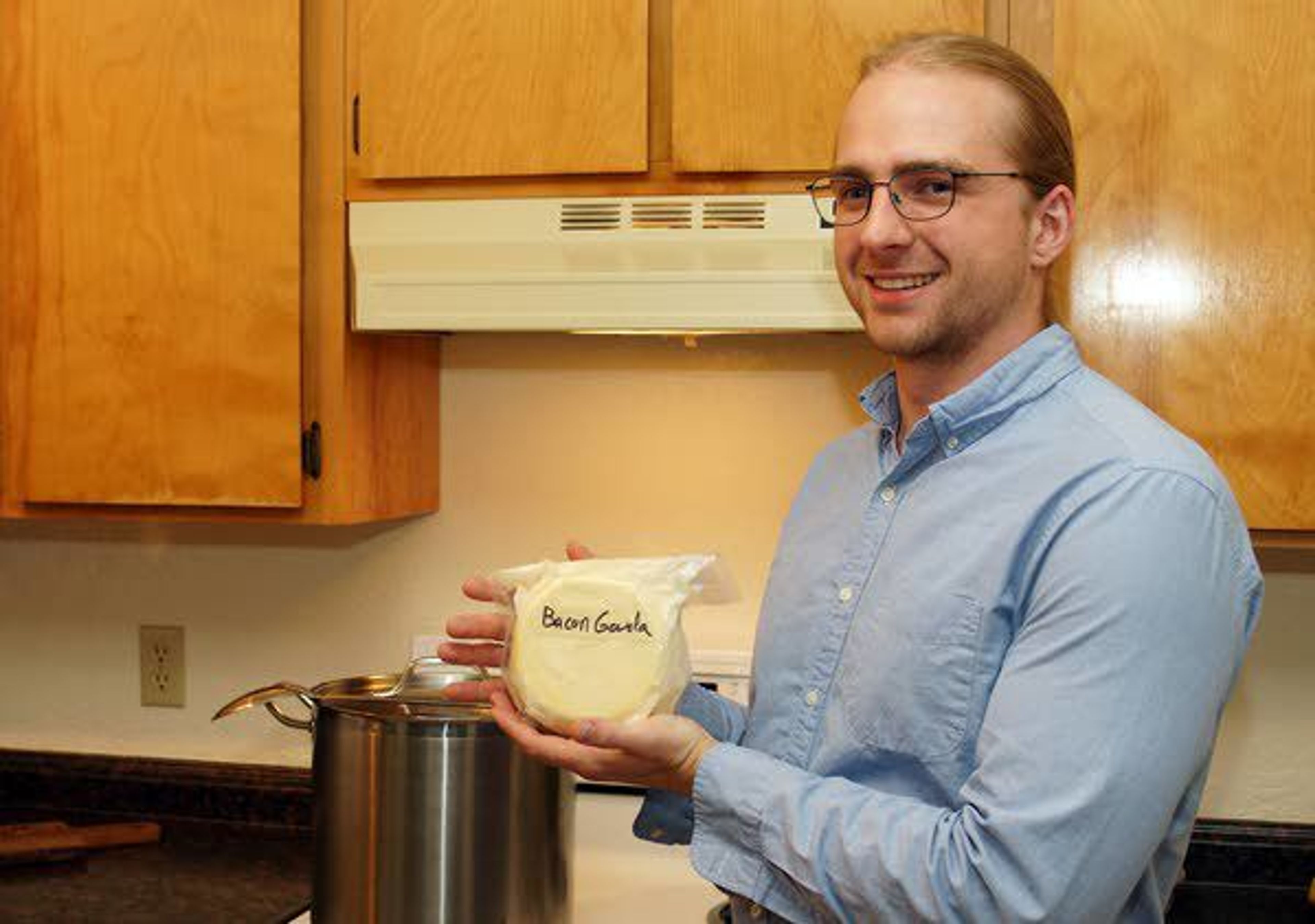 Jobe Ritchie holds a package of bacon gouda cheese he made.