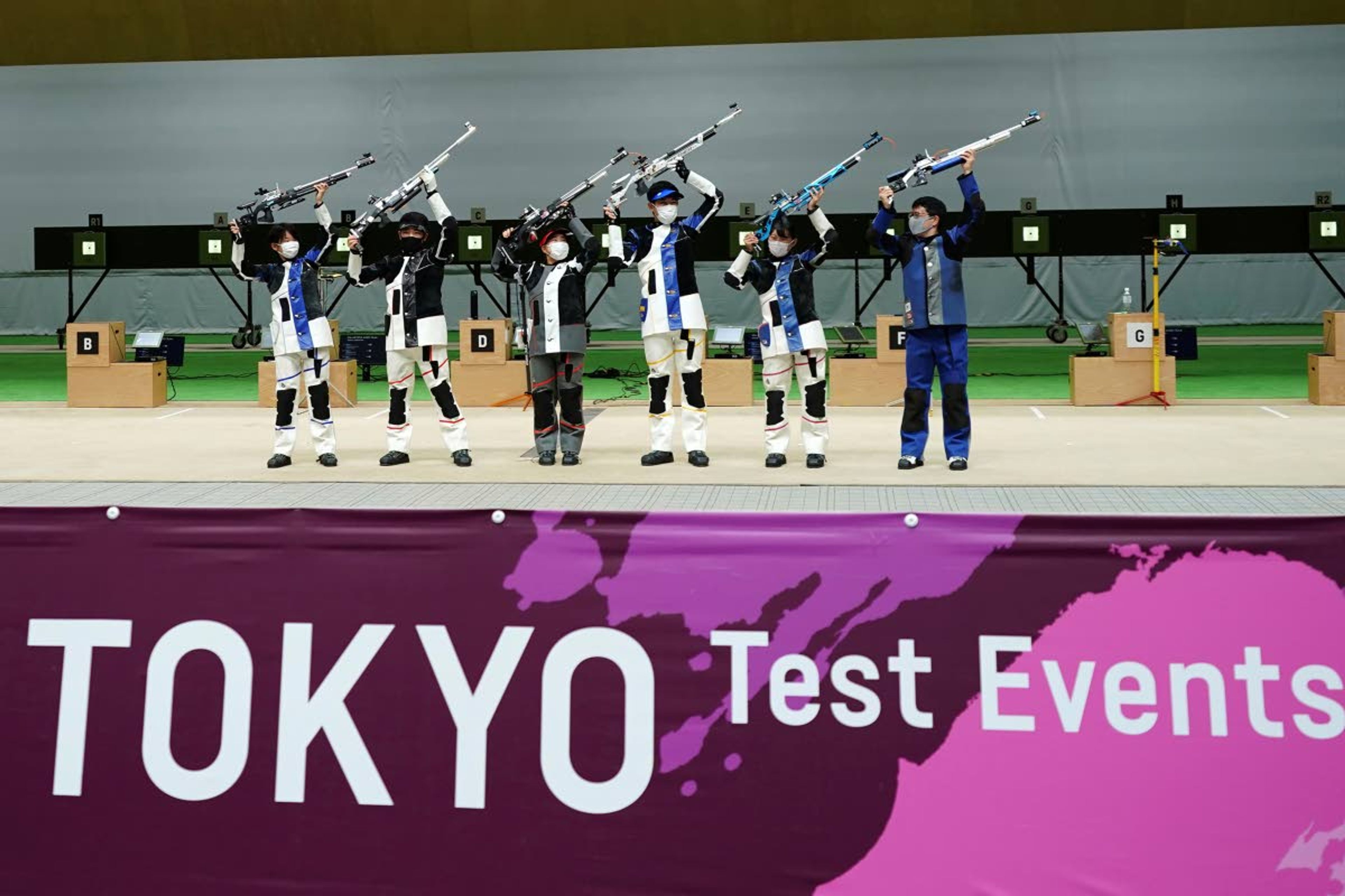 FILE - In this May 18, 2021, file photo, winning athletes pose after the finals of the 10m Air Rifle Mixed Team competition during the Tokyo 2020 Olympic Game Shooting test event at Asaka Shooting Range in Tokyo. IOC officials say the Tokyo Olympics will open on July 23 and almost nothing now can stop the games from going forward.(AP Photo/Eugene Hoshiko, File)