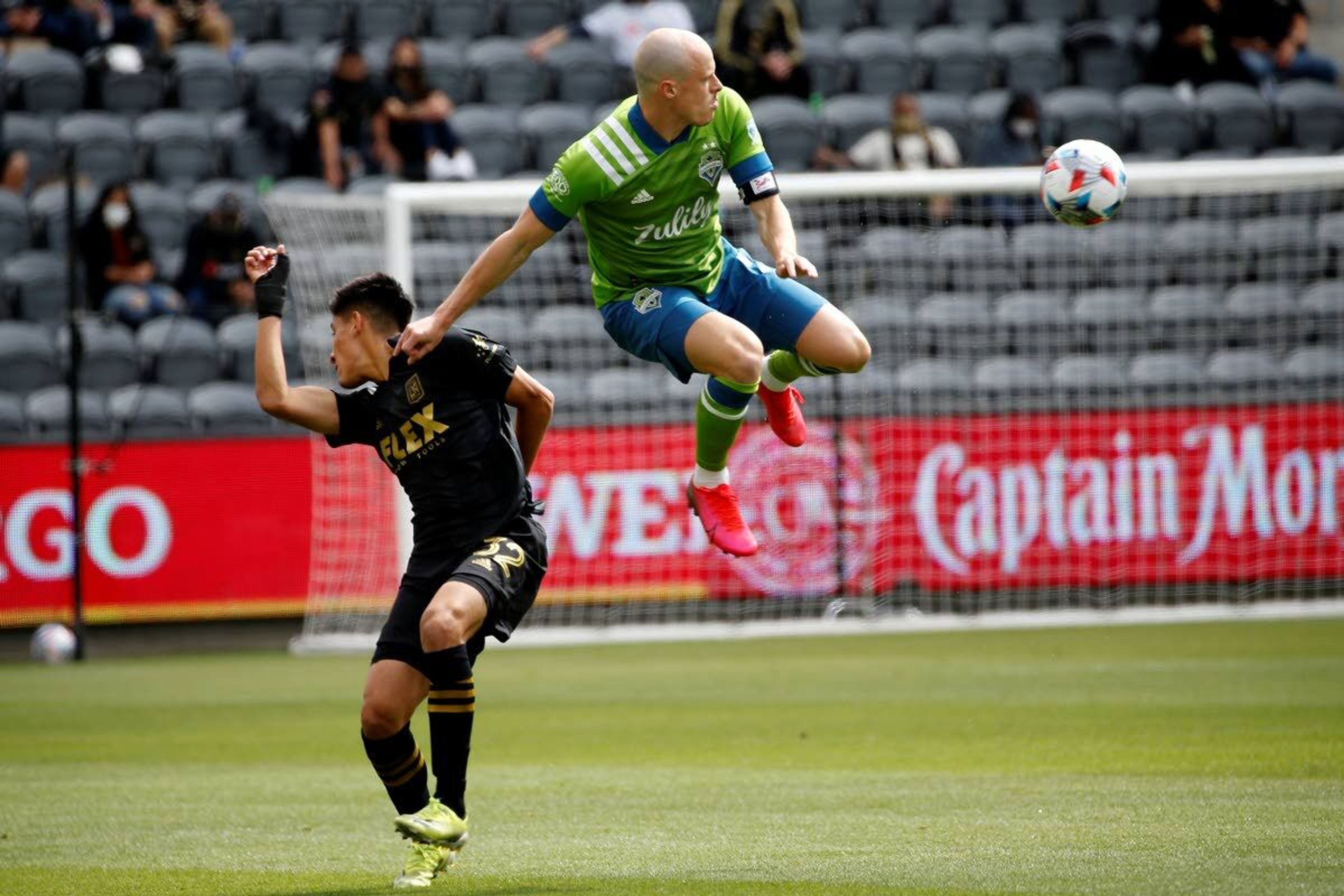 Seattle Sounders defender Brad Smith, right, goes up for the ball next to Los Angeles FC mdefended Marco Farfan (32) during the first half of an MLS soccer match, Saturday, April 24, 2021, in Los Angeles. (AP Photo/Ringo H.W. Chiu)