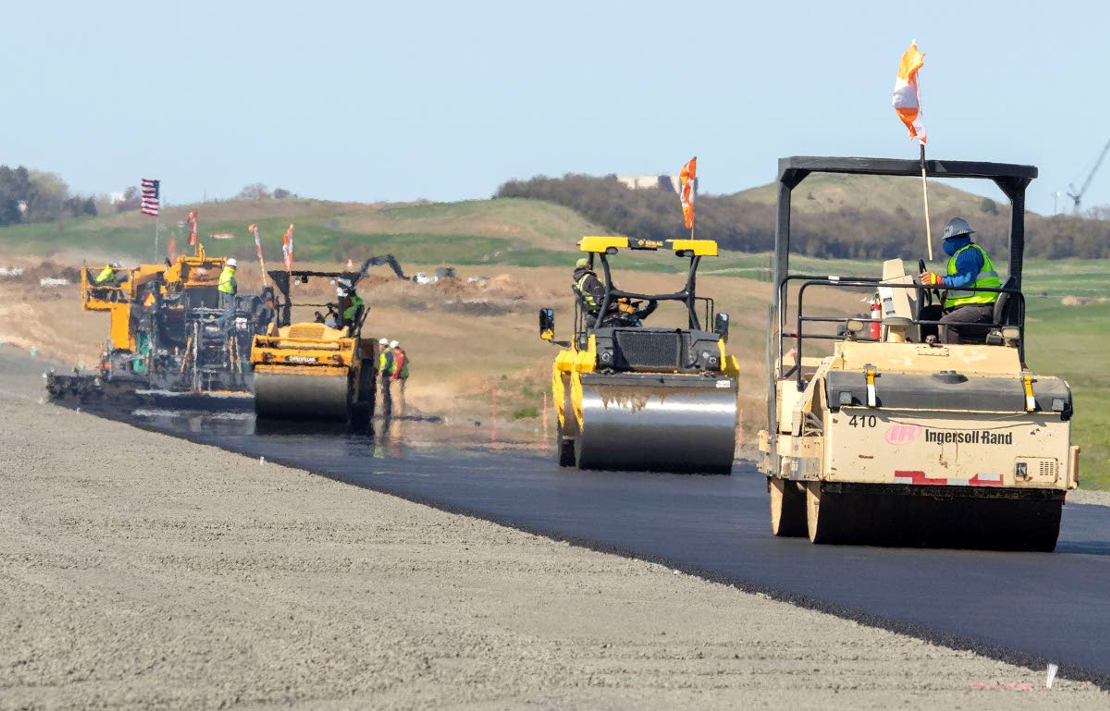 Rollers from Poe Asphalt Paving work on a project to pave the new runway on Wednesday at the Pullman-Moscow Regional Airport. The paving machine will make 24 passes down the runway to lay nine inches of asphalt in four layers. The existing runway will close on Sept. 8, with the new runway scheduled to open on Oct. 4.