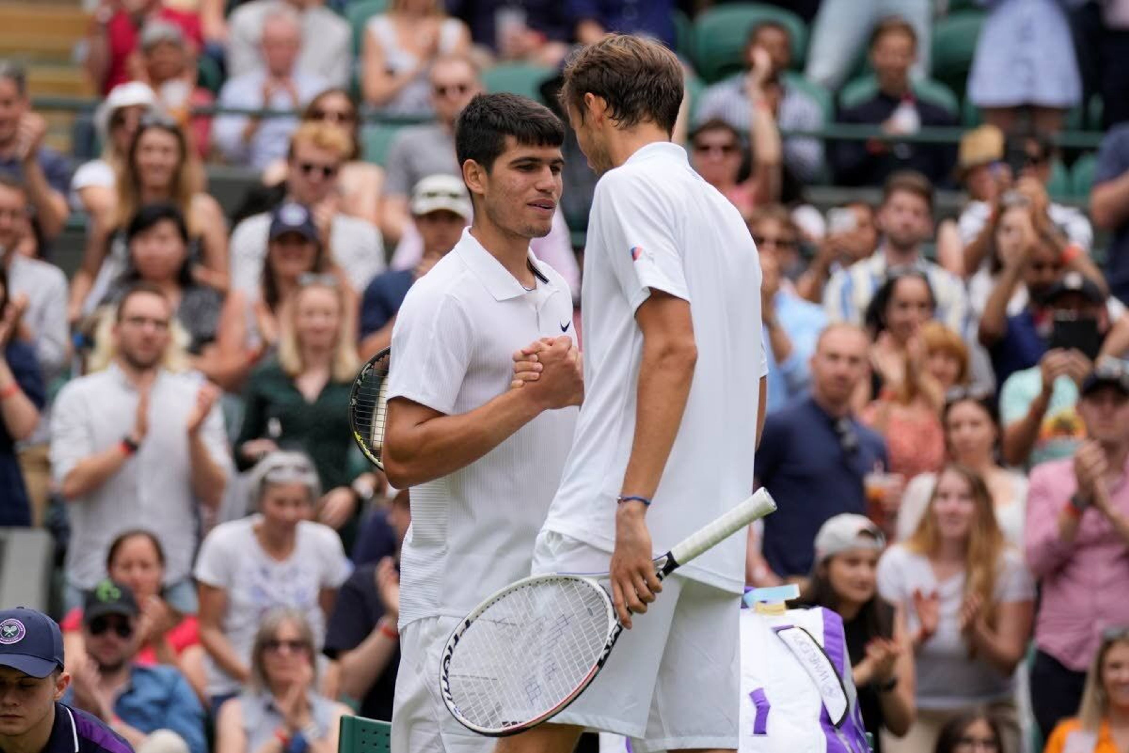 Russia's Daniil Medvedev shakes hands with Spain's Carlos Alcaraz, left, after winning the men's singles second round match on day four of the Wimbledon Tennis Championships in London, Thursday July 1, 2021. (AP Photo/Kirsty Wigglesworth)